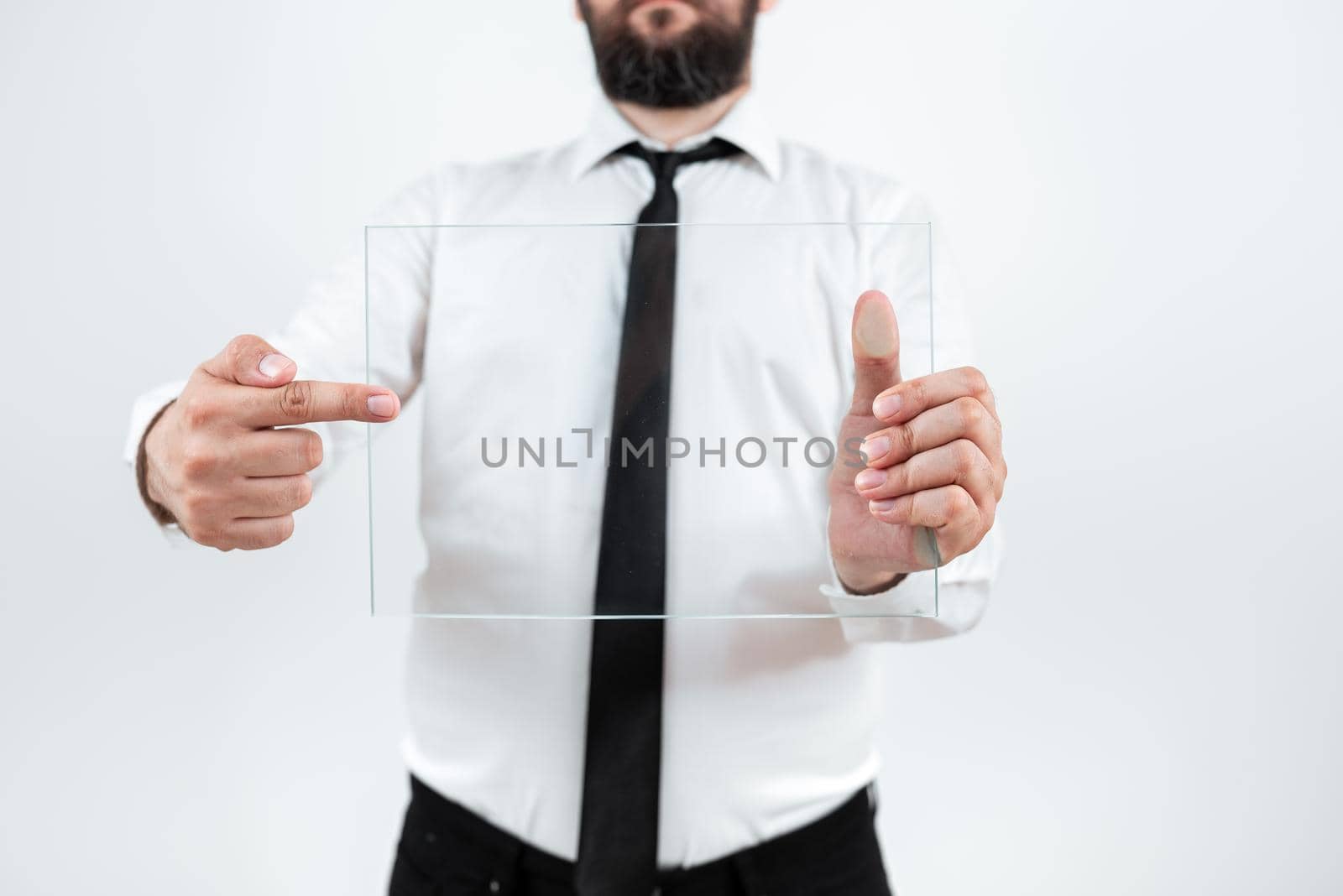 Male Corporate Holding And Pointing At Transparent Glass While Presenting Sales Data. Man Wearing Necktie Displaying New Ideas And Strategies For Achieving The Goals. by nialowwa