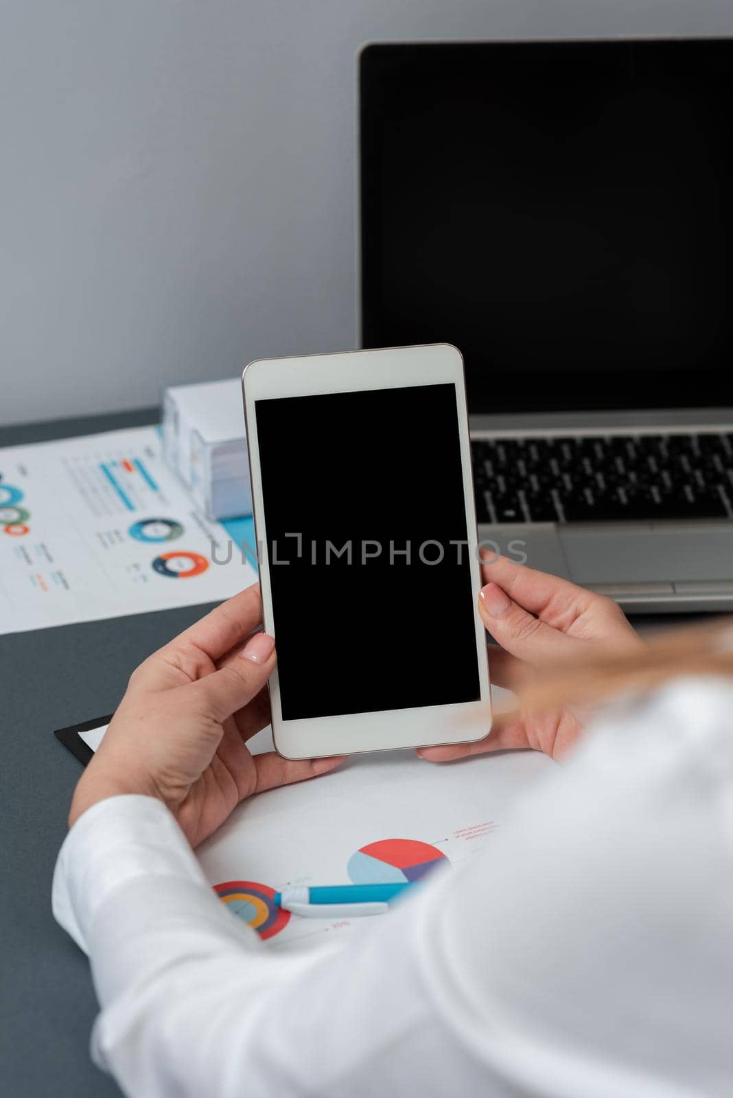 Businesswoman Holding Tablet With Important Message On It. Woman In Office Having Phone Screen With Crutial Informations. Executive Presenting Critical New On Cellphone. by nialowwa