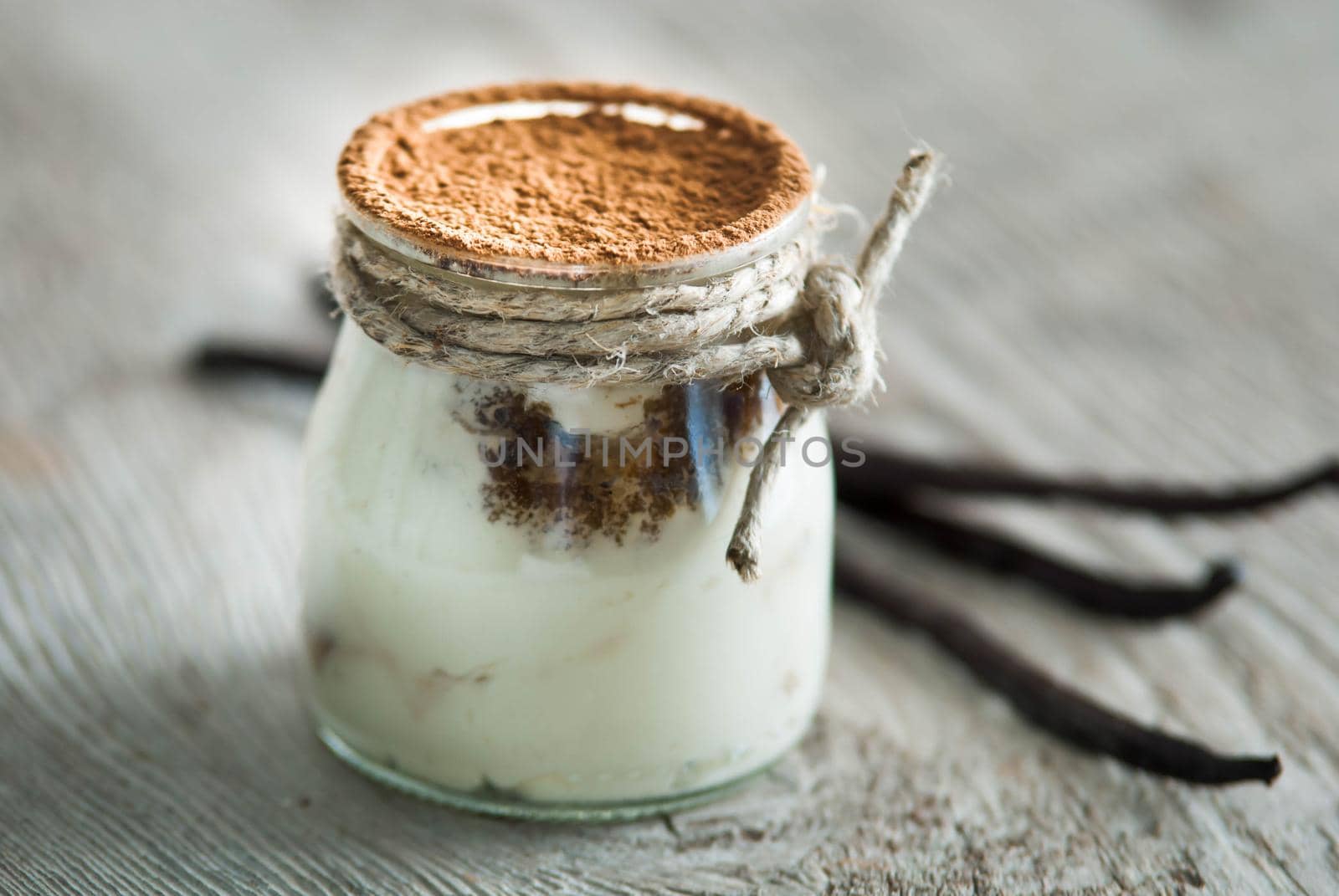 sweet italian desert tiramisu in glass on wooden background