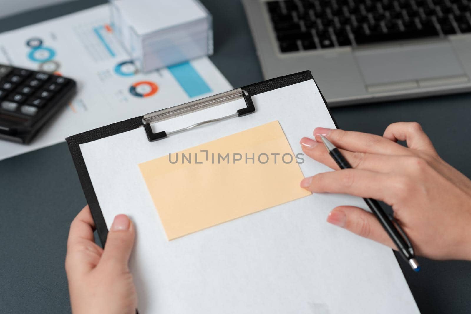 Woman Holding Pen And Clipboard With Note On It With Important Messages.