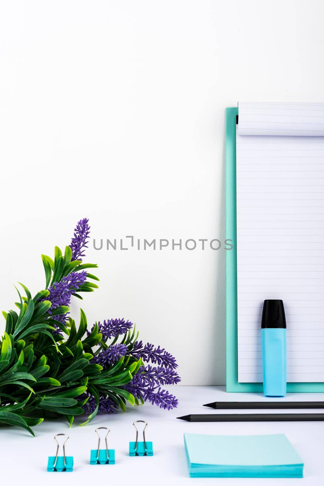 Flowers On Desk Placed Next To Clipboard With Important Message.