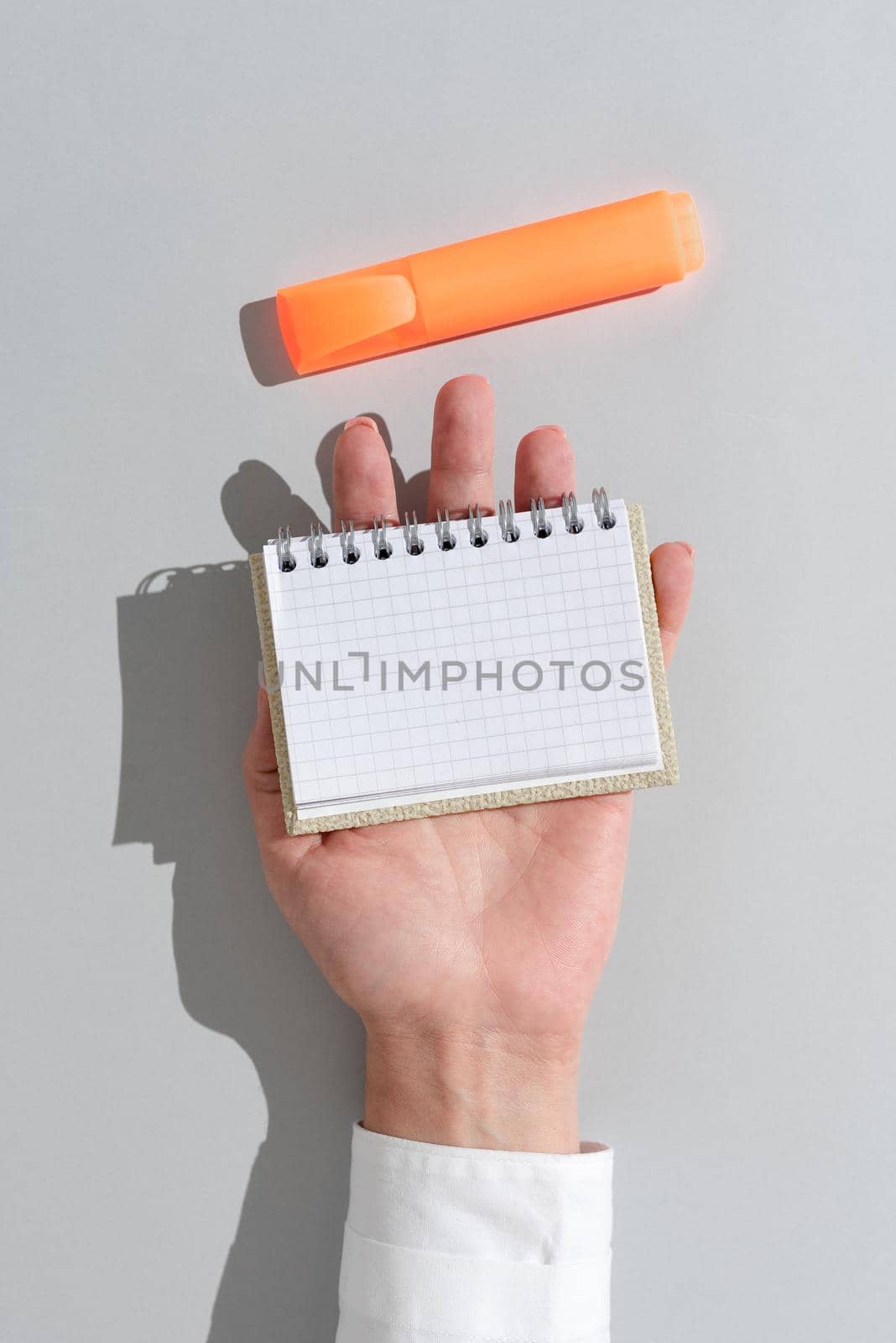 Businesswoman Holding Notepad With Important Message On Office Desk With Marker. Woman Presenting Crutial Information On Notebook. Executive Showing Critical Announcement. by nialowwa