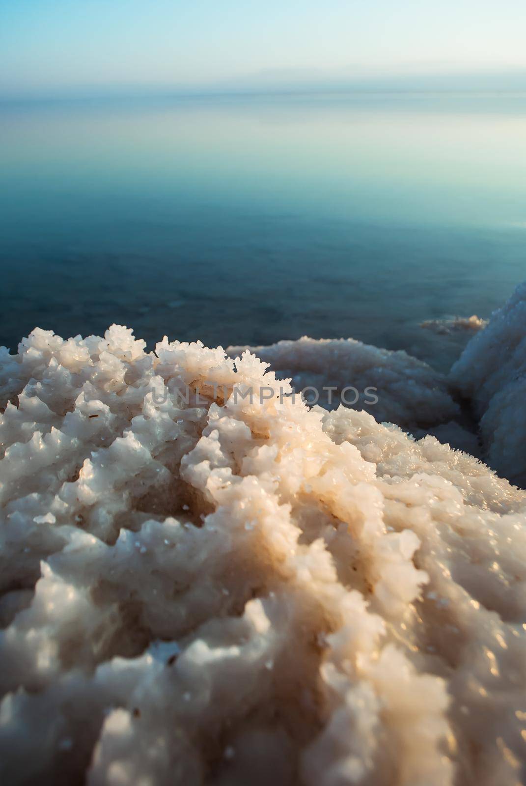 Beautiful sunrise at Dead Sea in Israel wih rocks of salt at foreground