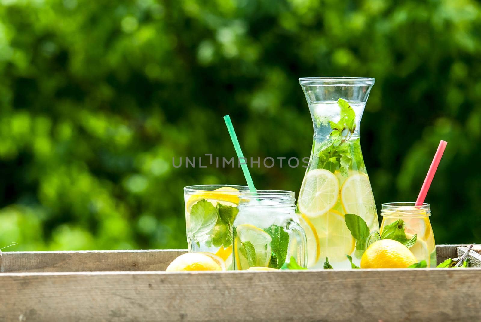 fresh homemade lemonade in pincher and jar of green bluered background