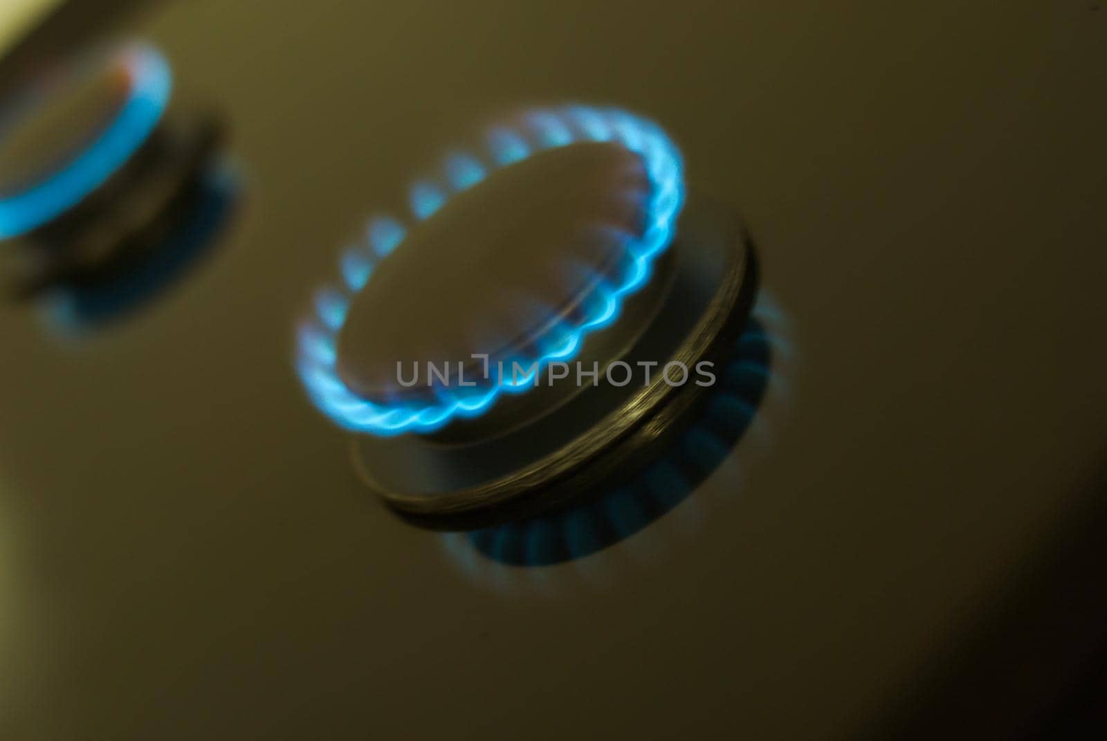 abstract gas burner with blue flame on dark background