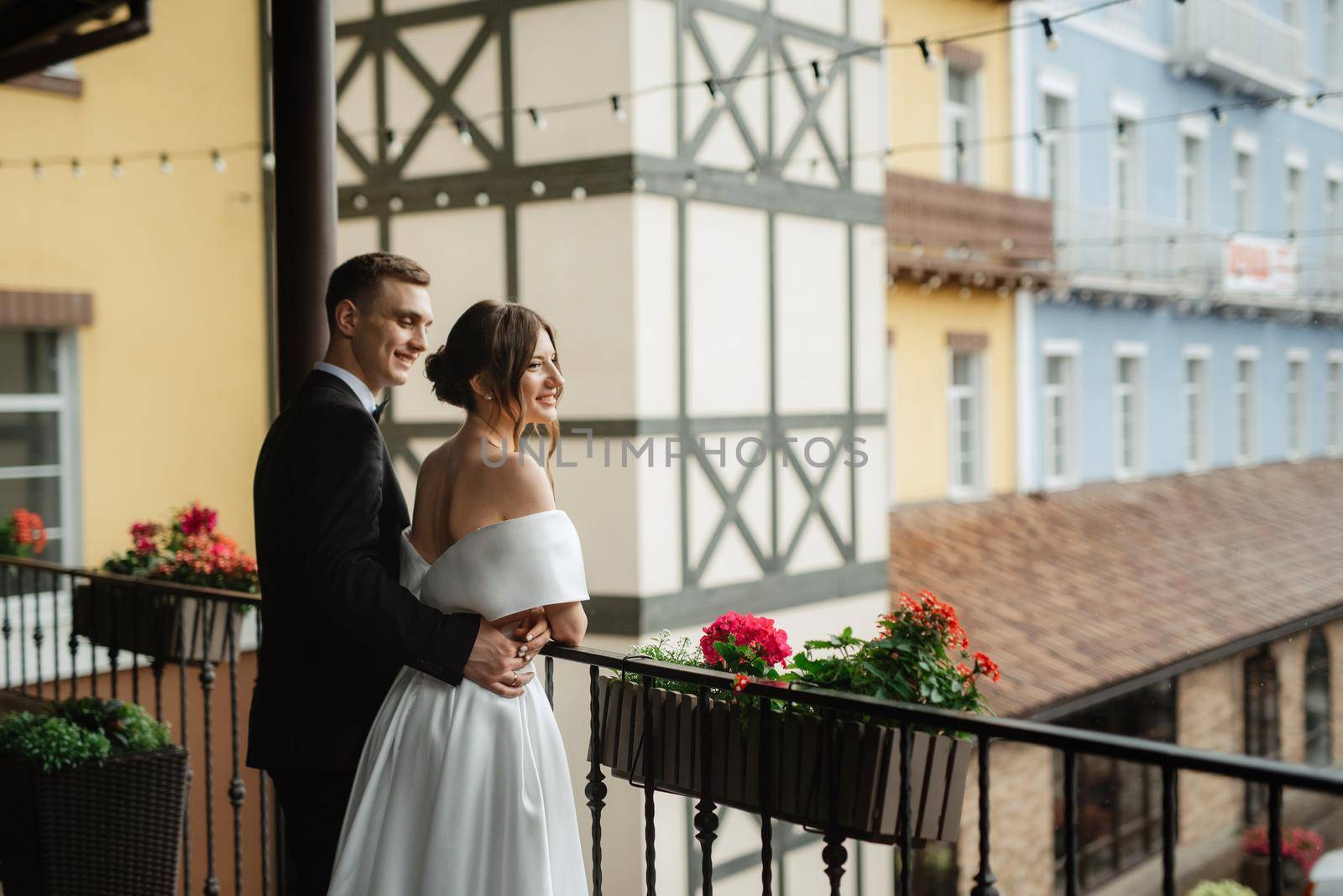 young couple bride and groom in a white short dress walking in the rain