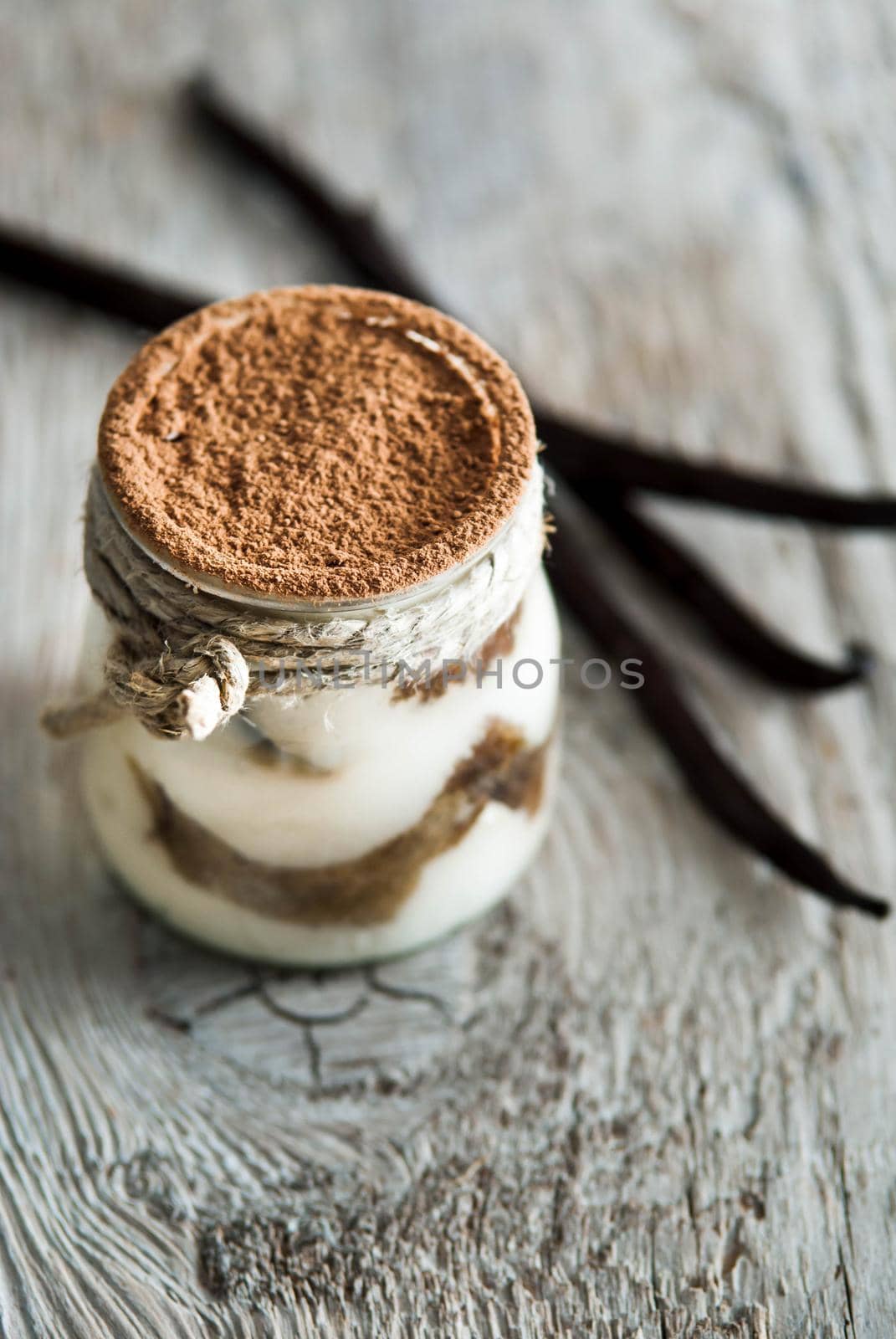 sweet italian desert tiramisu in glass on wooden background