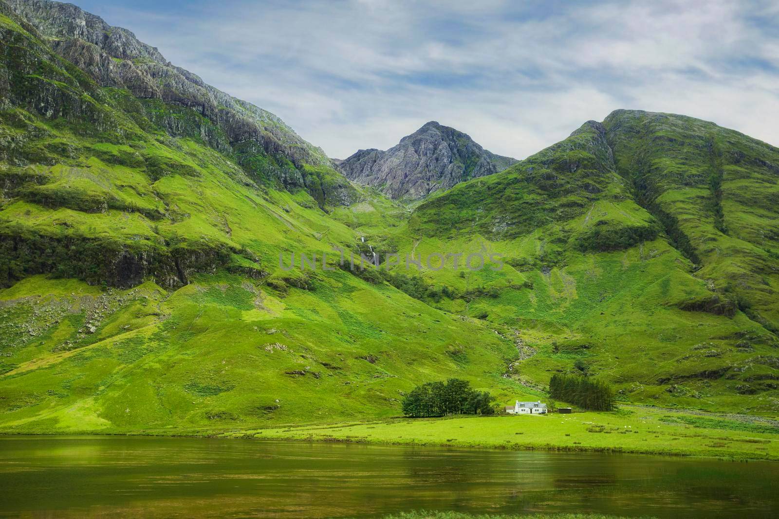 Achnambeithach cottage on Loch Achtriochtan under Aonach Dubh waterfall and Bidean nam Bian mountain, Glencoe valley, Scotland, UK