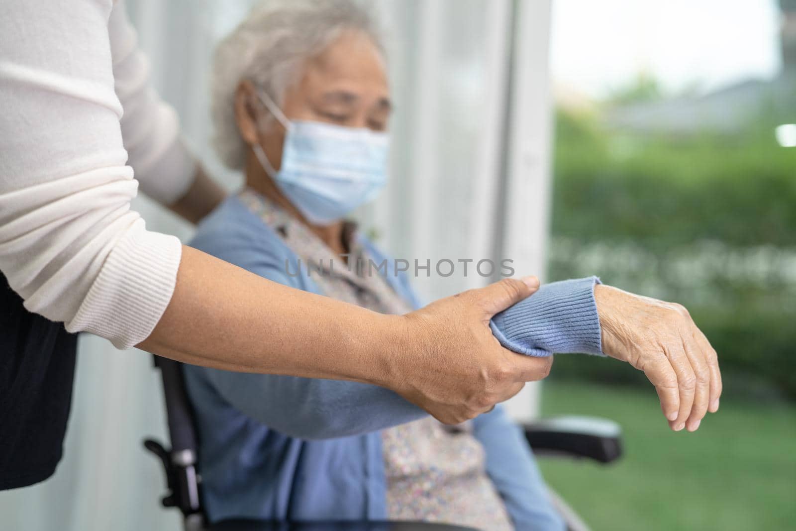 Help Asian senior or elderly old lady woman sitting on wheelchair and wearing a face mask for protect safety infection Covid19 Coronavirus. by pamai