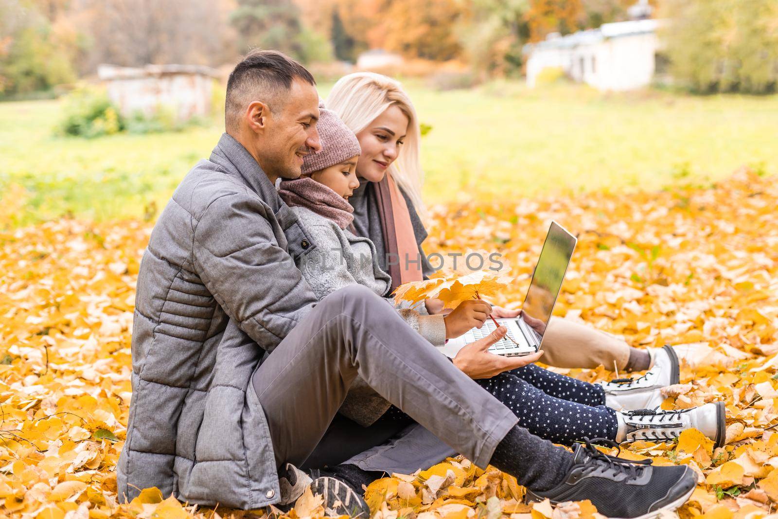 Family with laptop on an autumn day.