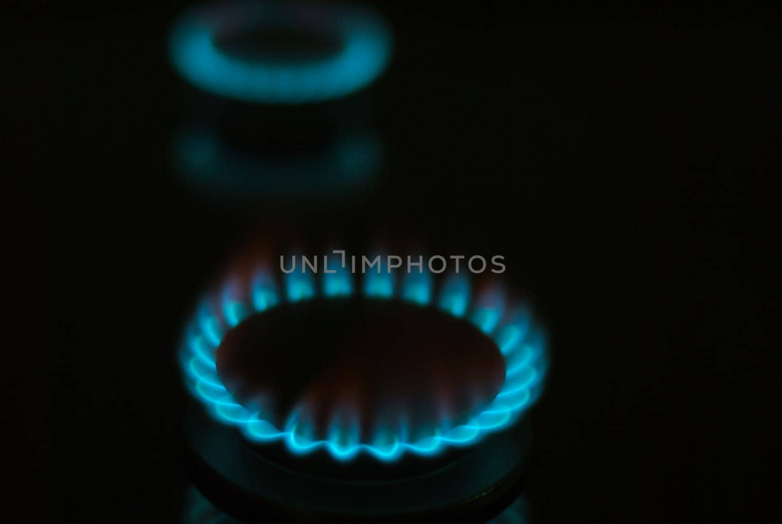 abstract gas burner with blue flame on dark background