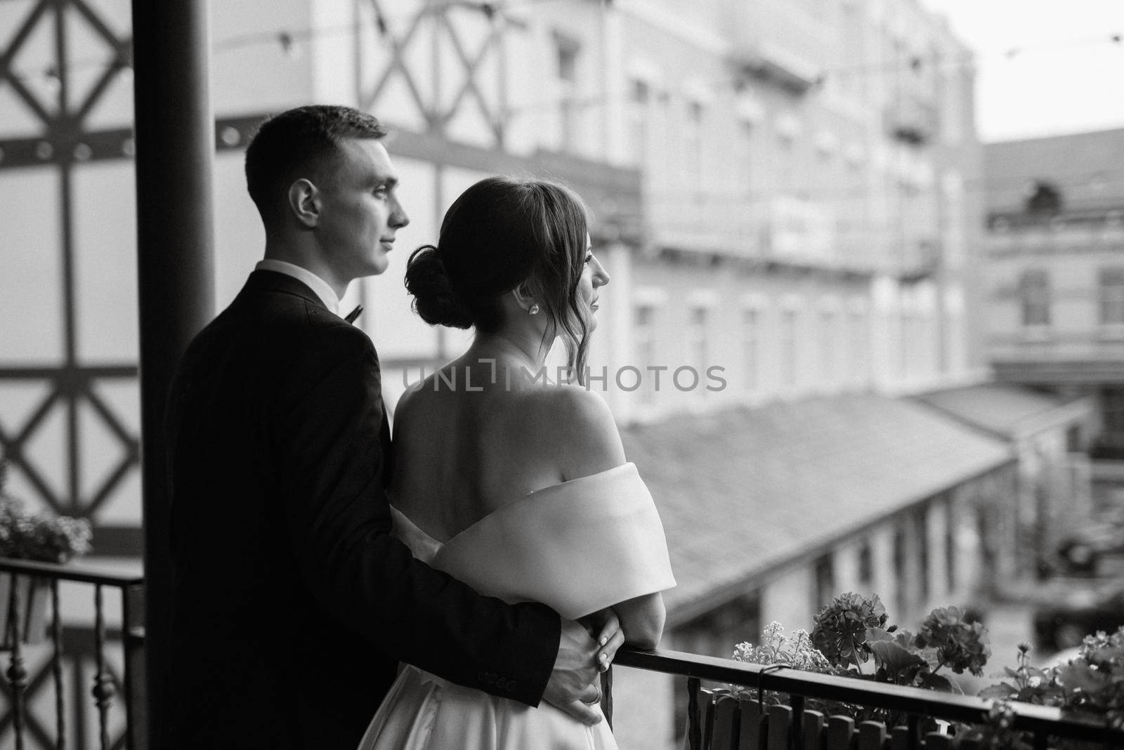 young couple bride and groom in a white short dress walking in the rain