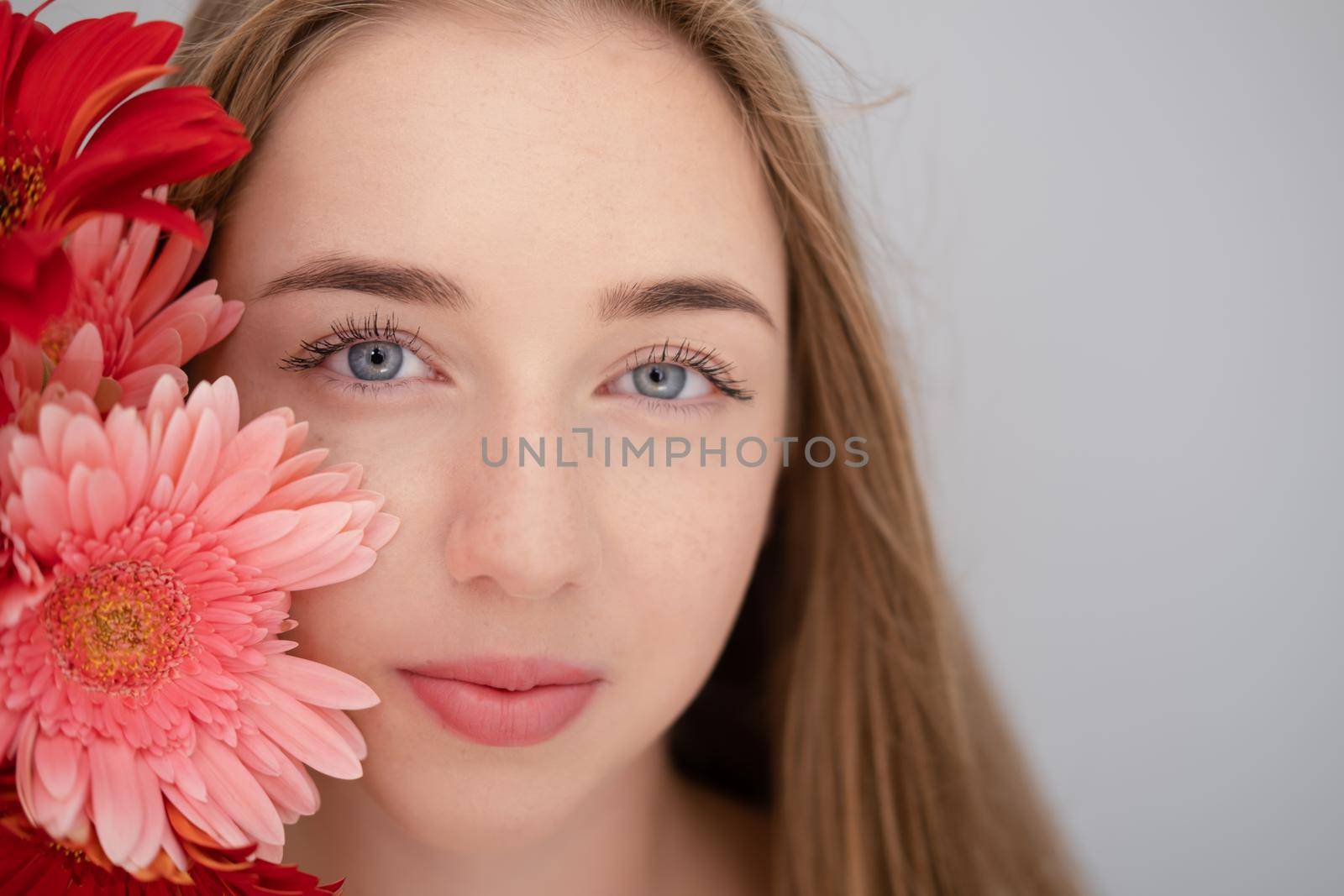 Portrait of pretty young woman with pink and red chrysanthemum flowers.