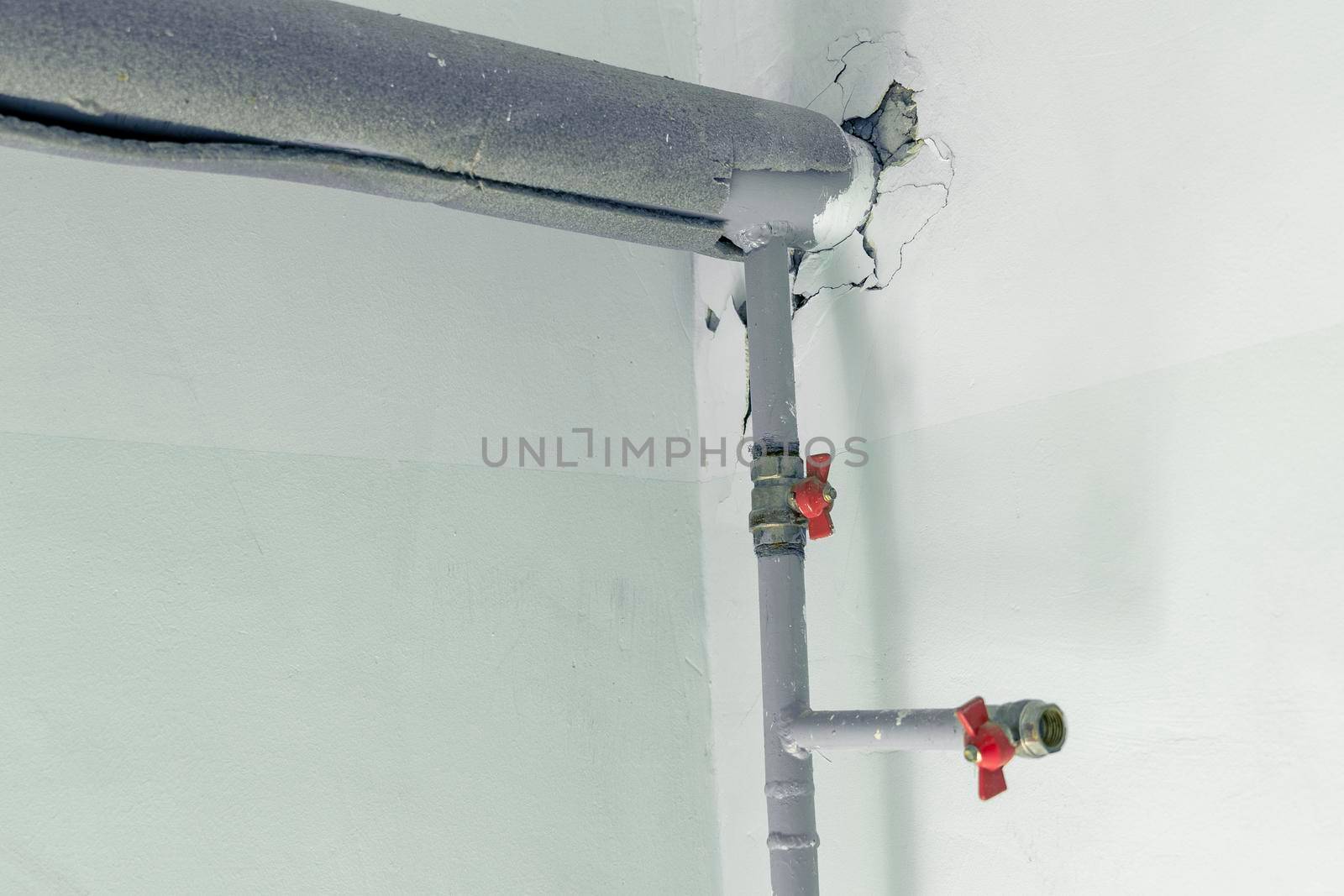 metal water pipes on the wall in a room with valves and fittings by audiznam2609