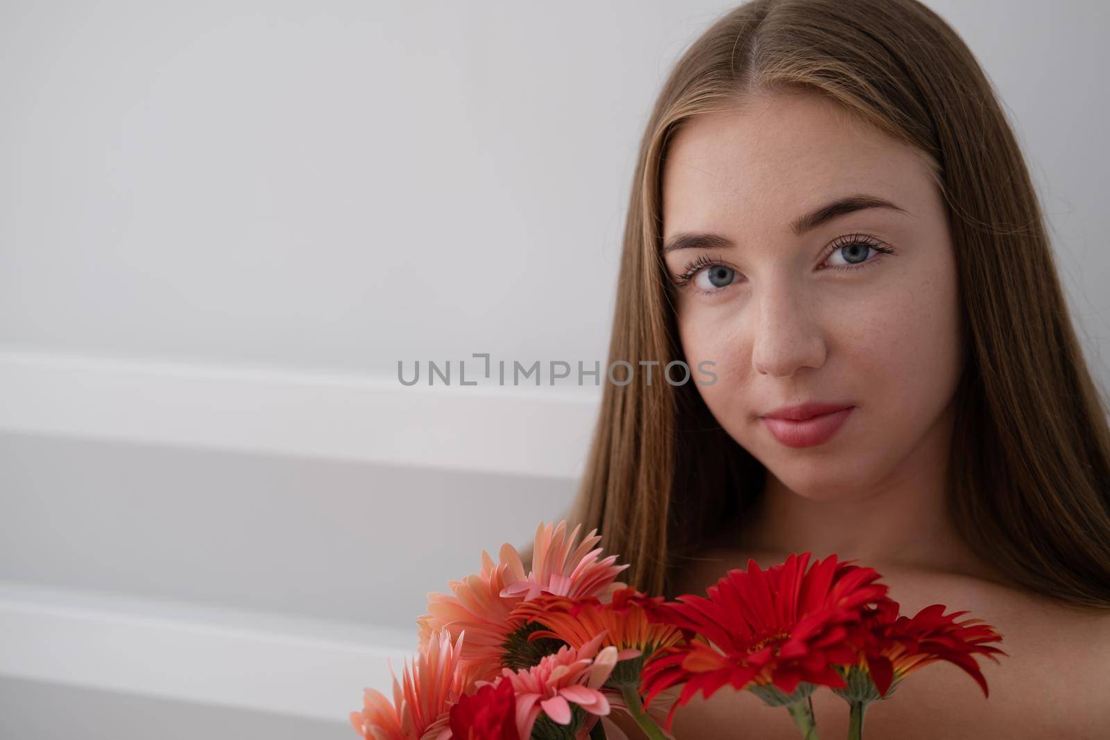 Portrait of pretty young woman with pink and red chrysanthemum flowers.