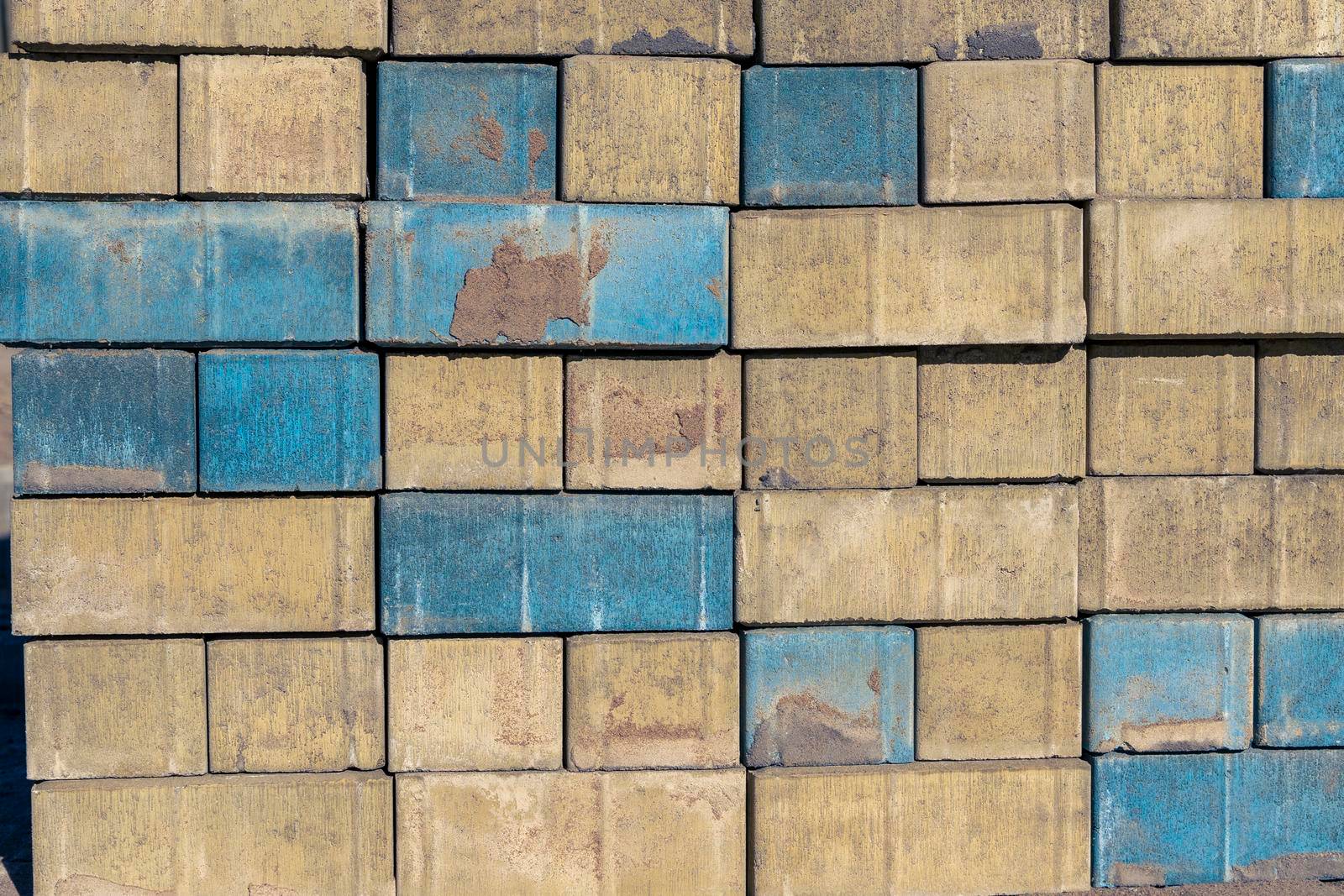 background of multicolored paving slabs for paving paths. yellow-blue bricks with a rough texture. paving slabs