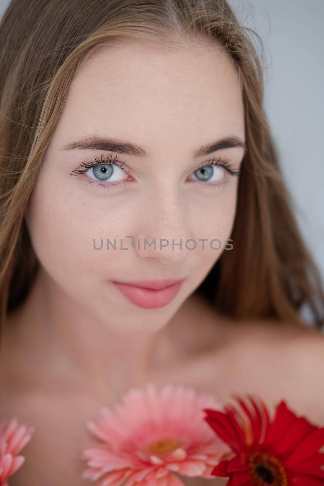 Portrait of pretty young woman with pink and red chrysanthemum flowers.