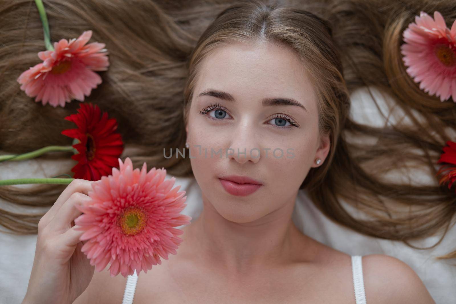 Portrait of pretty young woman with pink and red chrysanthemum flowers.