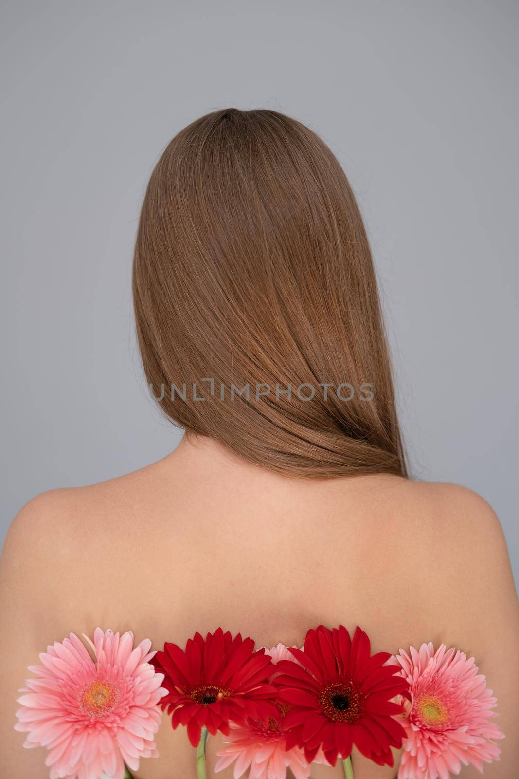 Portrait of pretty young woman with pink and red chrysanthemum flowers.