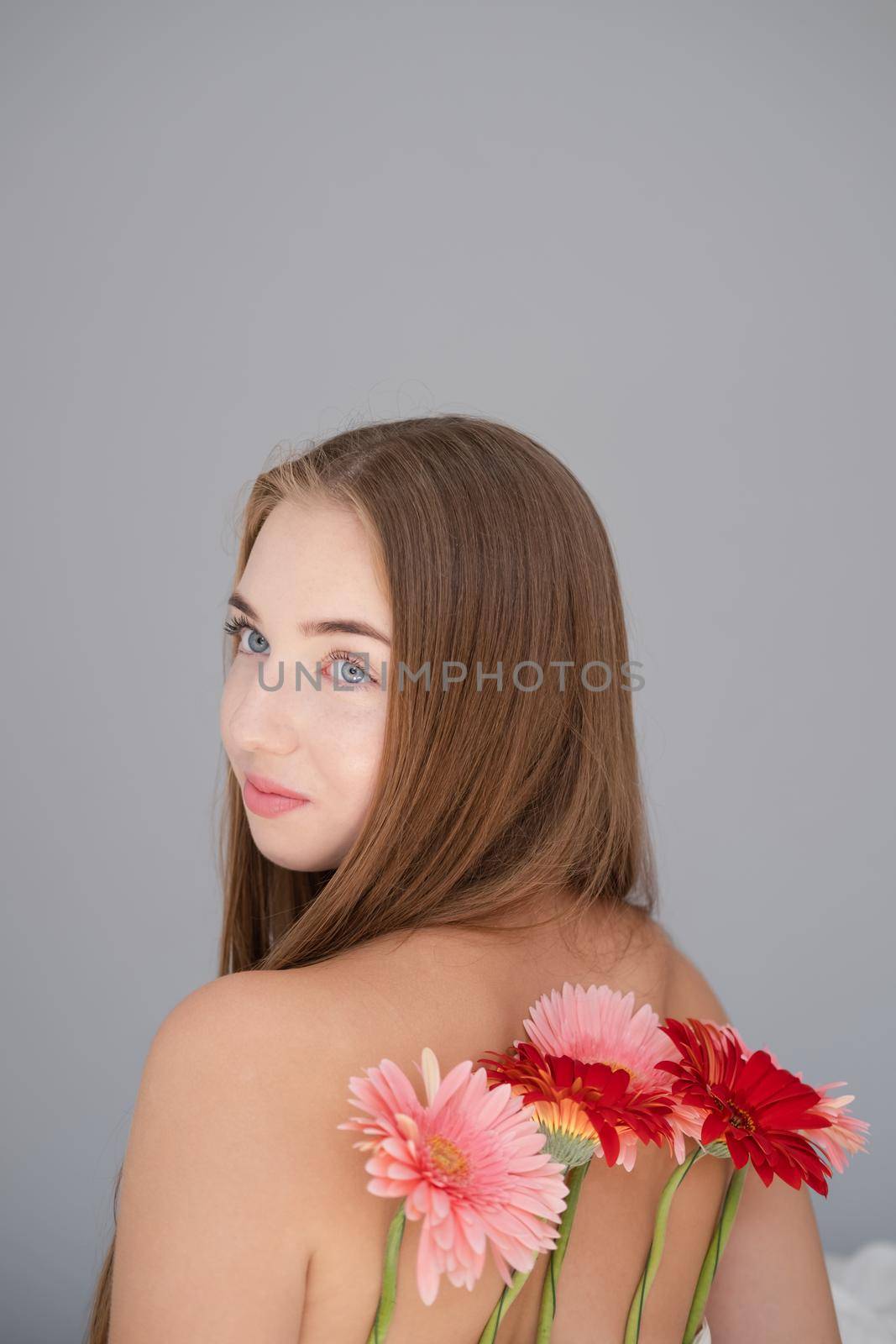 Portrait of pretty young woman with pink and red chrysanthemum flowers.