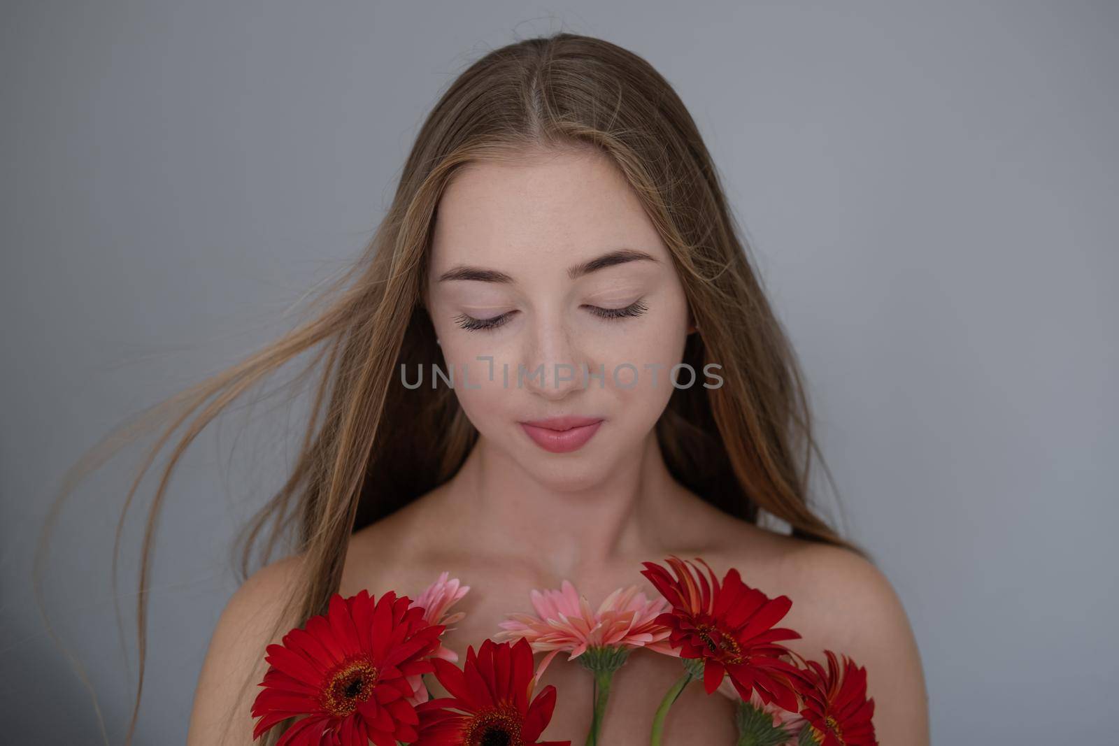 Portrait of pretty young woman with pink and red chrysanthemum flowers.