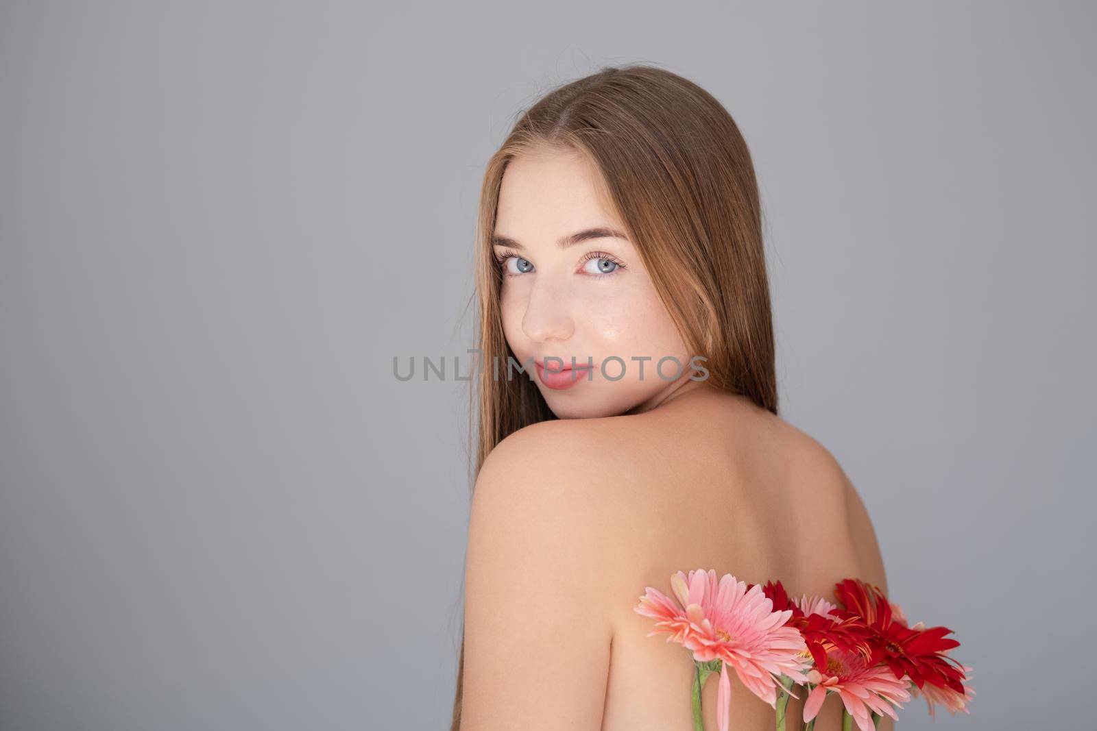 Portrait of pretty young woman with pink and red chrysanthemum flowers.