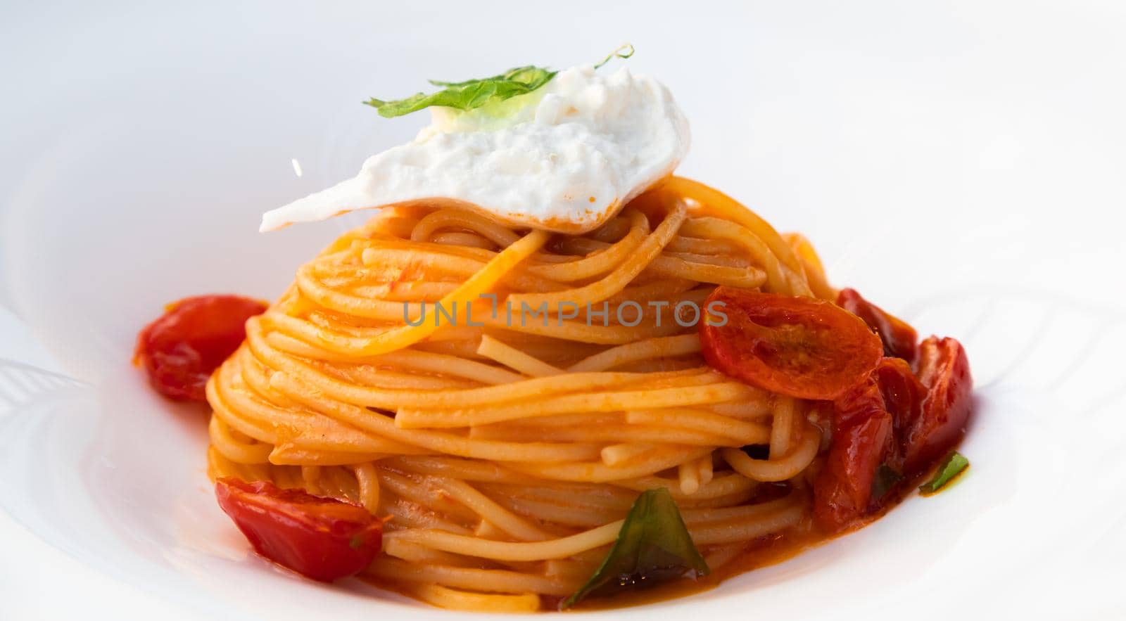 Italian pasta - spaghetti with burrata cheese closeup, mediterranean diet