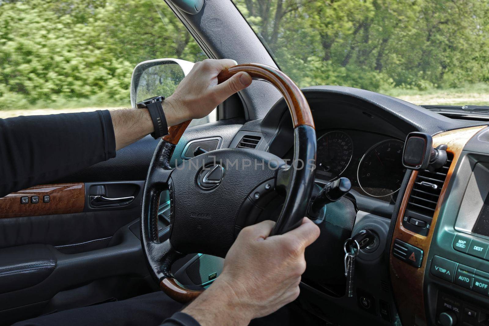 Male hands on the steering wheel of a Lexus GX-470 while the car is moving. Illustrative editorial of Lexus steering wheel close-up: Krasnodar, Russia- 11May 2022 by Proxima13