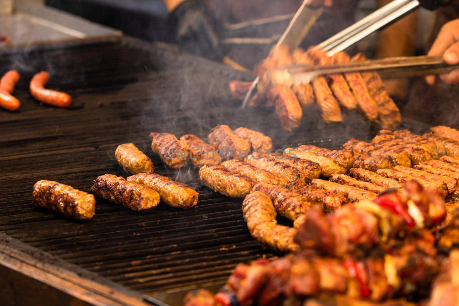Grilling tasty food on barbecue. Steak, sausages on grill at food festival