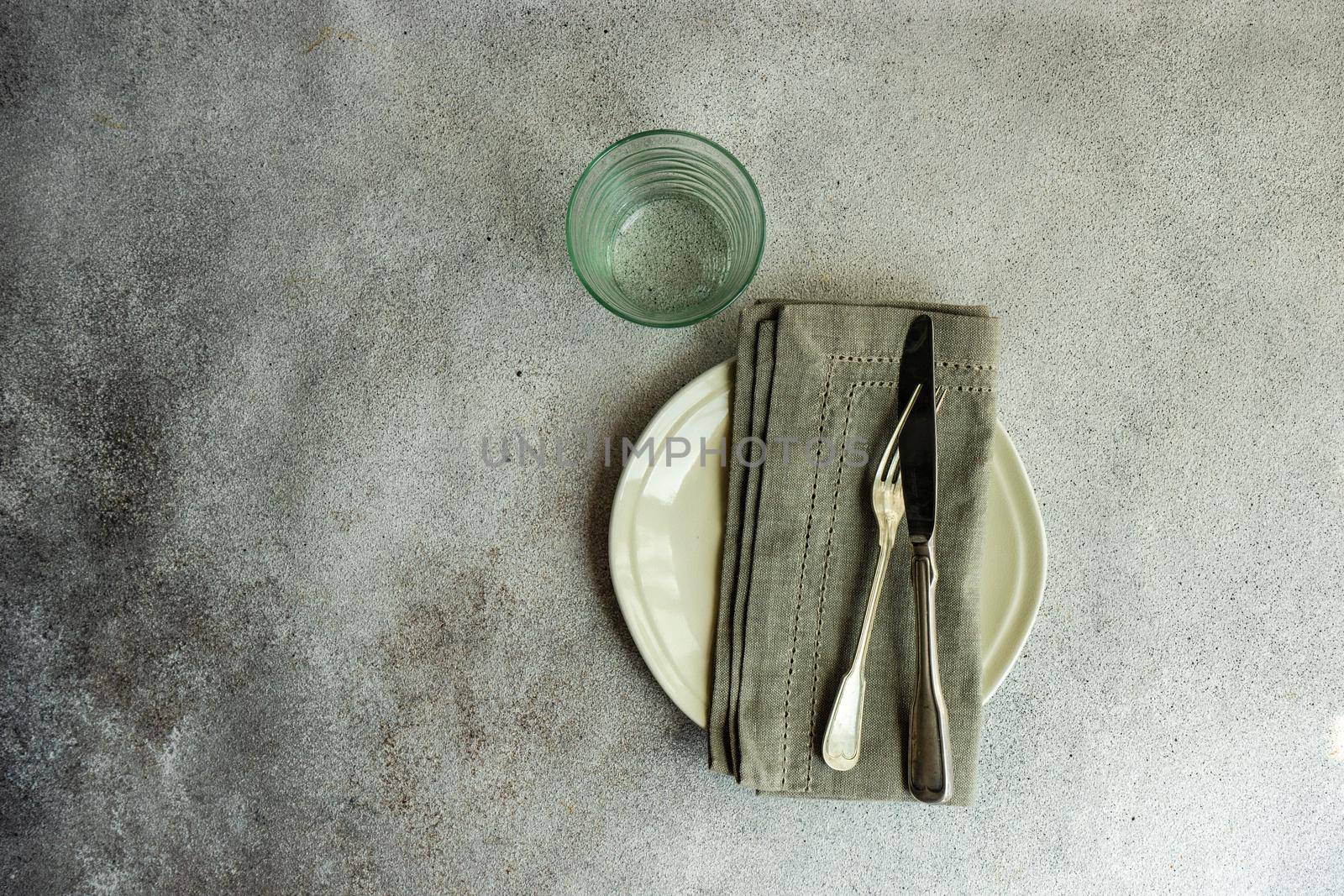 Overhead table setting in minimalistic style on concrete background