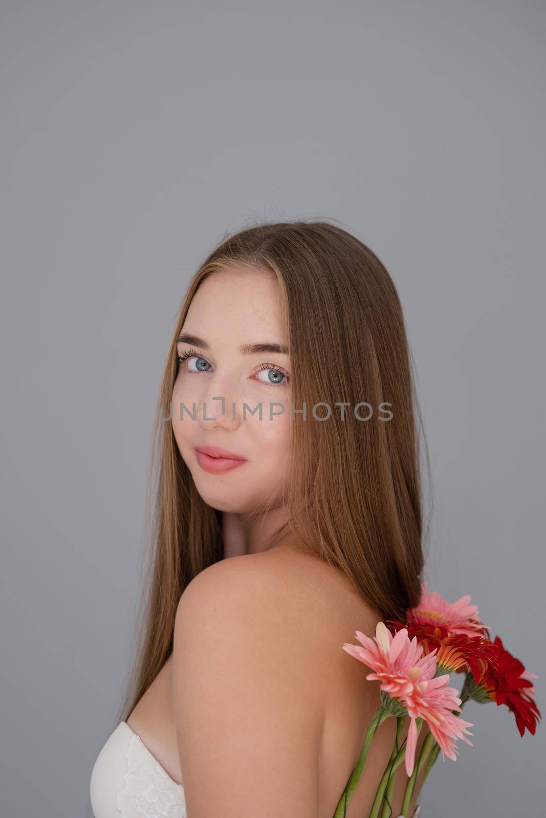 Portrait of pretty young woman with pink and red chrysanthemum flowers.