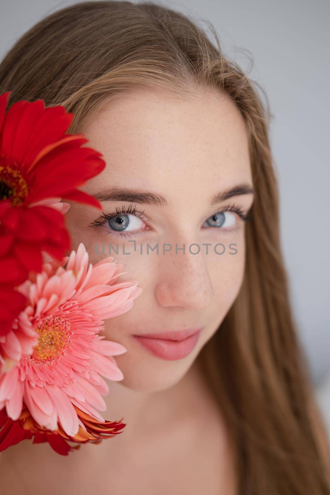 Portrait of pretty young woman with pink and red chrysanthemum flowers by oliavesna