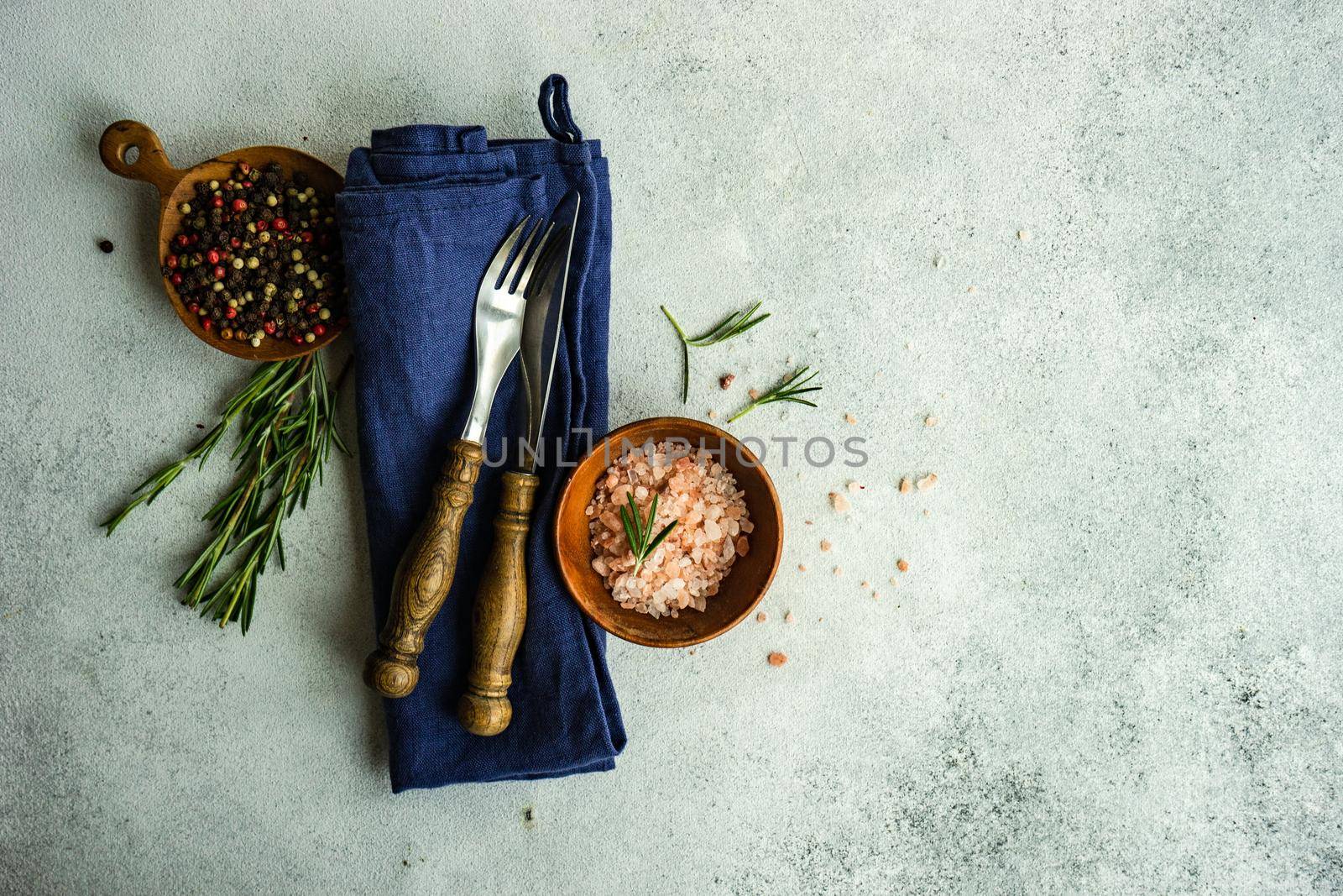 Cooking concept with spices and rosemary herb on concrete background