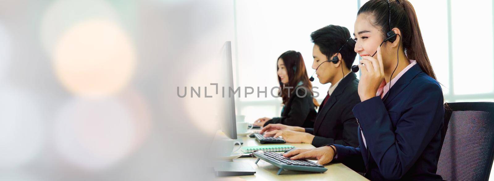 Business people wearing headset working in office in widen view to support remote customer or colleague. Call center, telemarketing, customer support agent provide service on telephone video call.