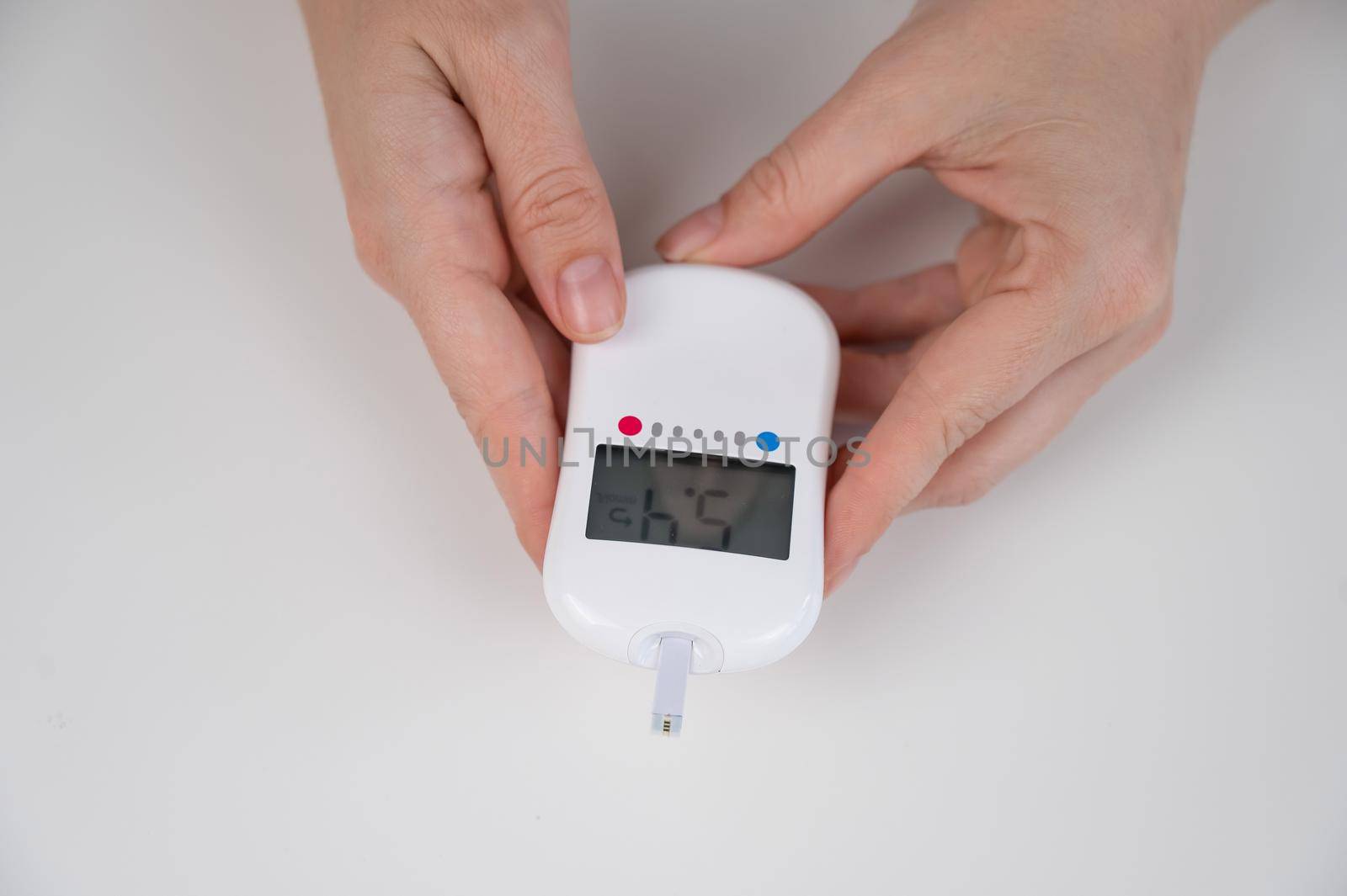 Woman measures blood sugar level with a glucometer