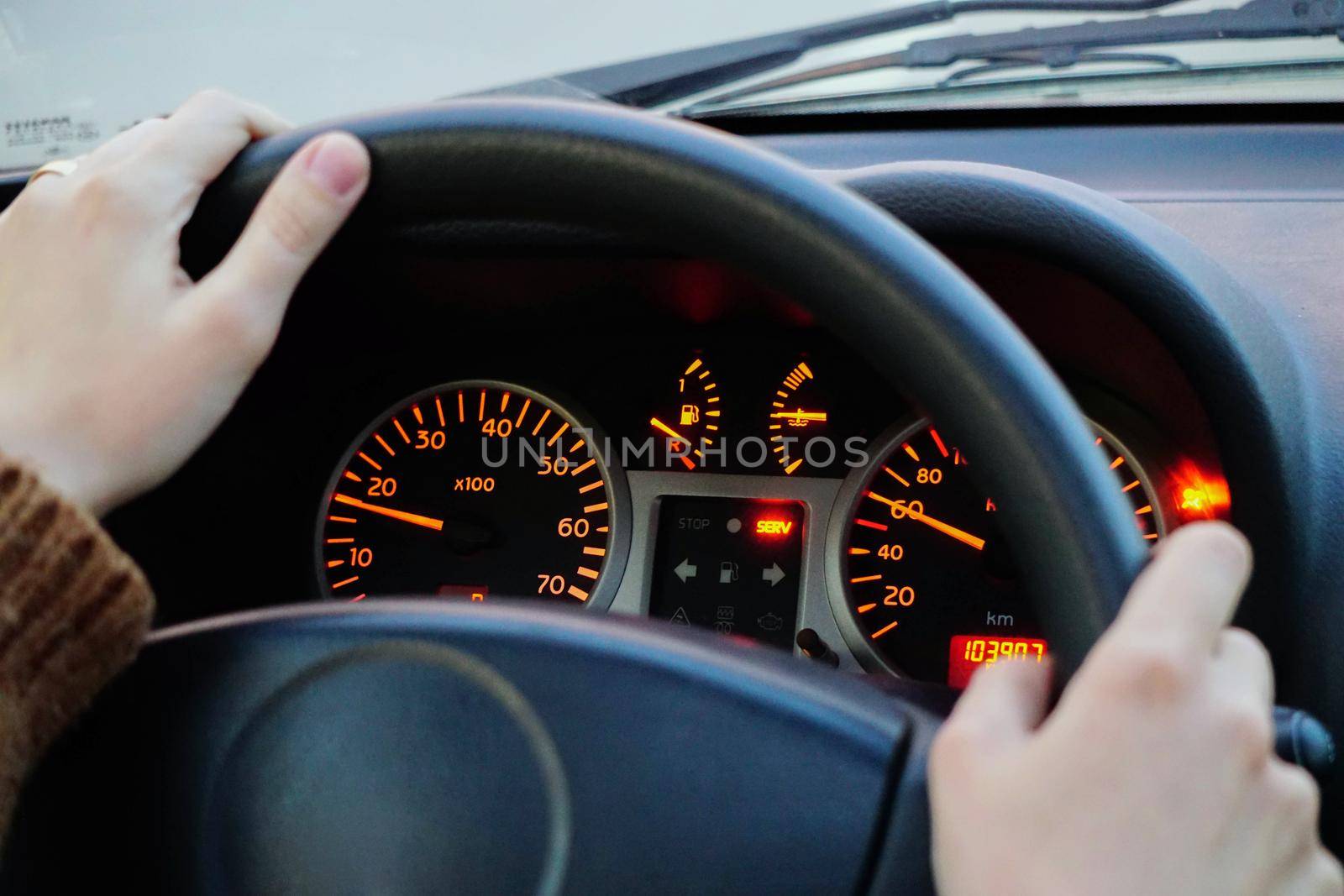 Car dashboard and drivers hand close up