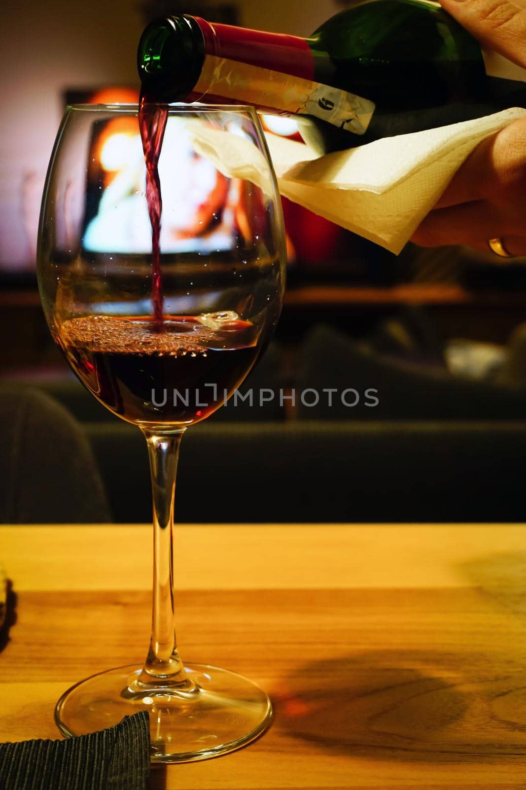 Pouring red wine in the glass close up view