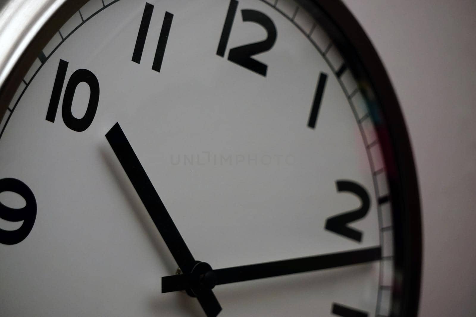 Wall clock with white base and black dials close up view