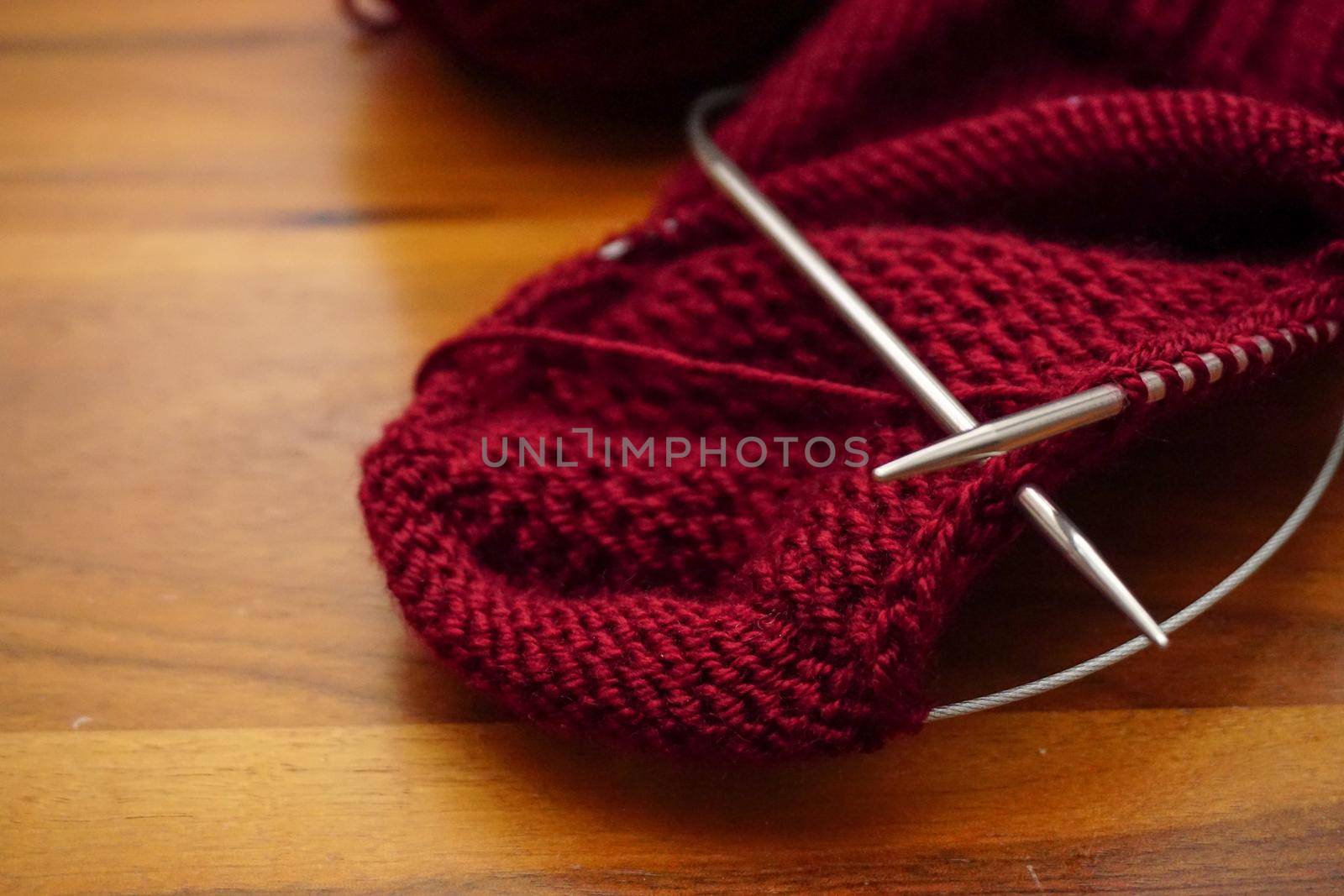 Wool knitting on wooden table close up by tasci