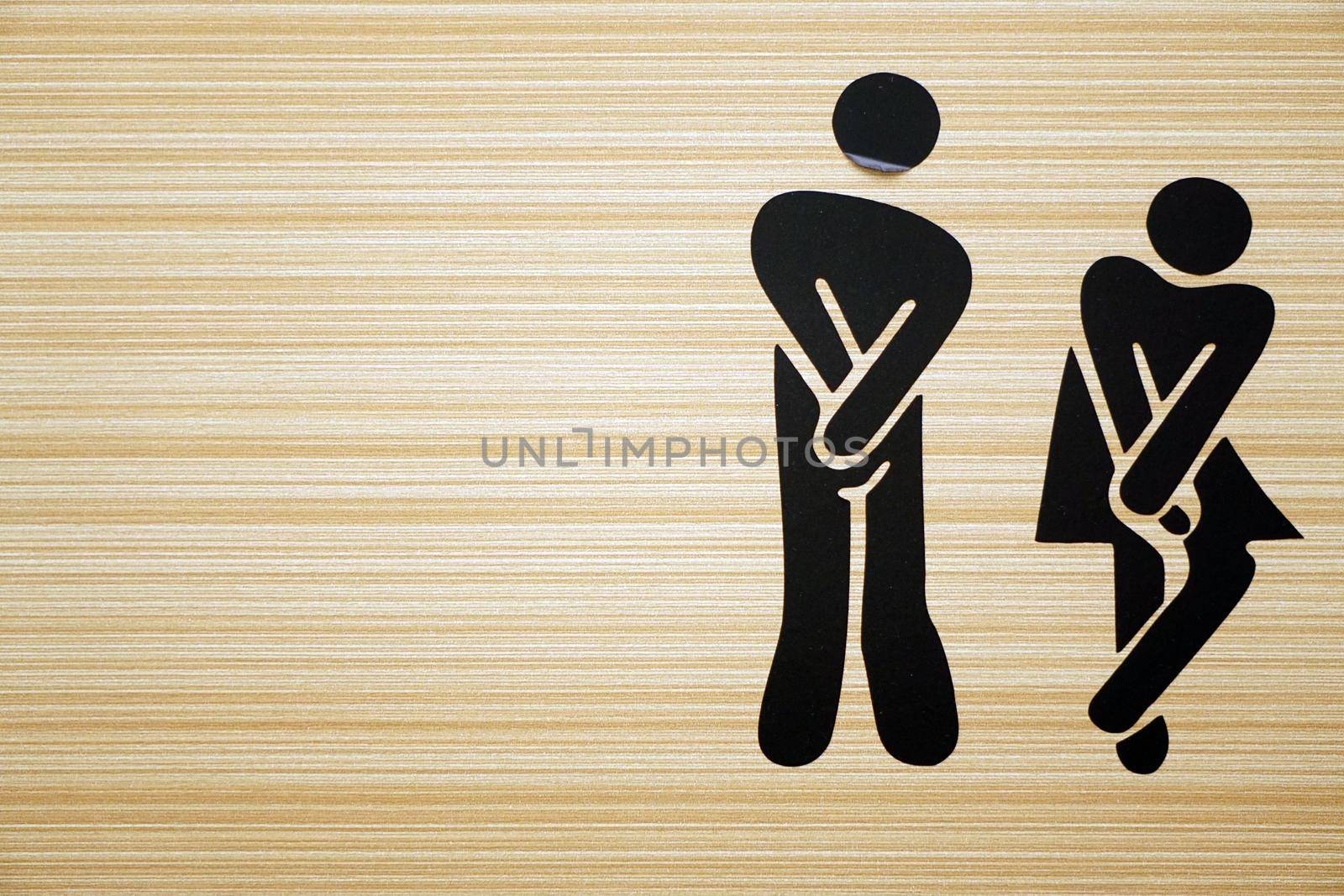 Comic toilet sign symbols with woman and men on wooden background
