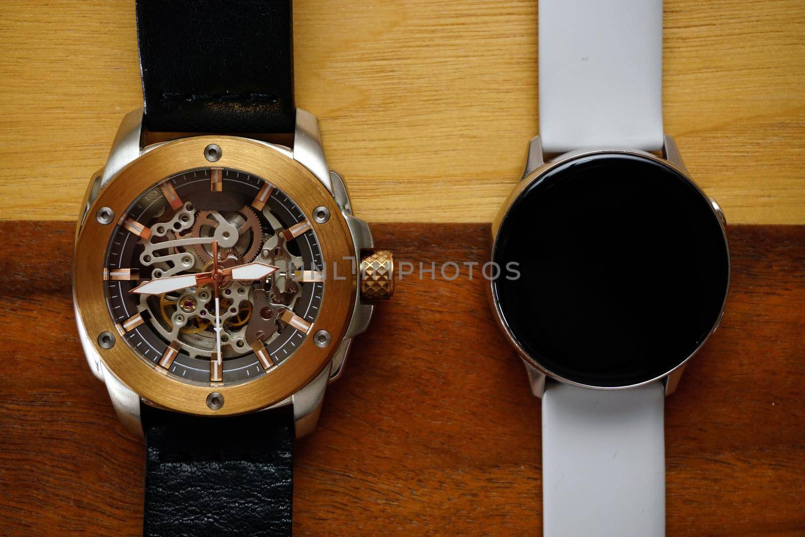 Analog and smart watches on wooden background with copyspace