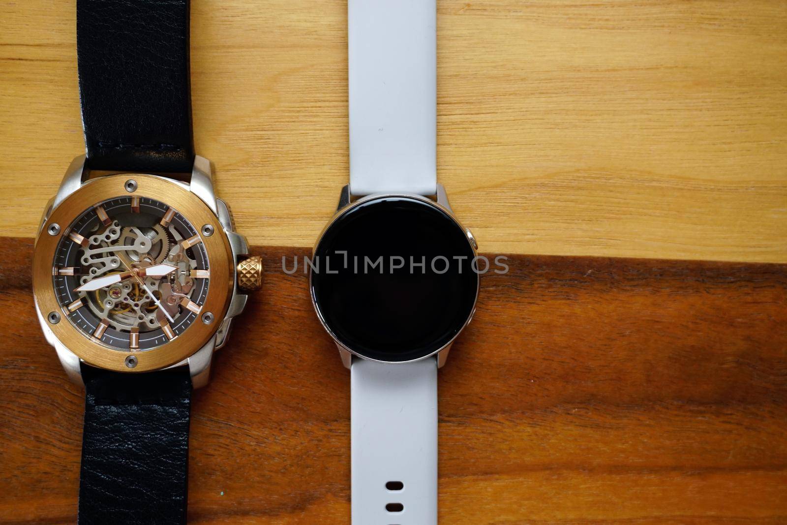 Analog and smart watches on wooden background with copyspace