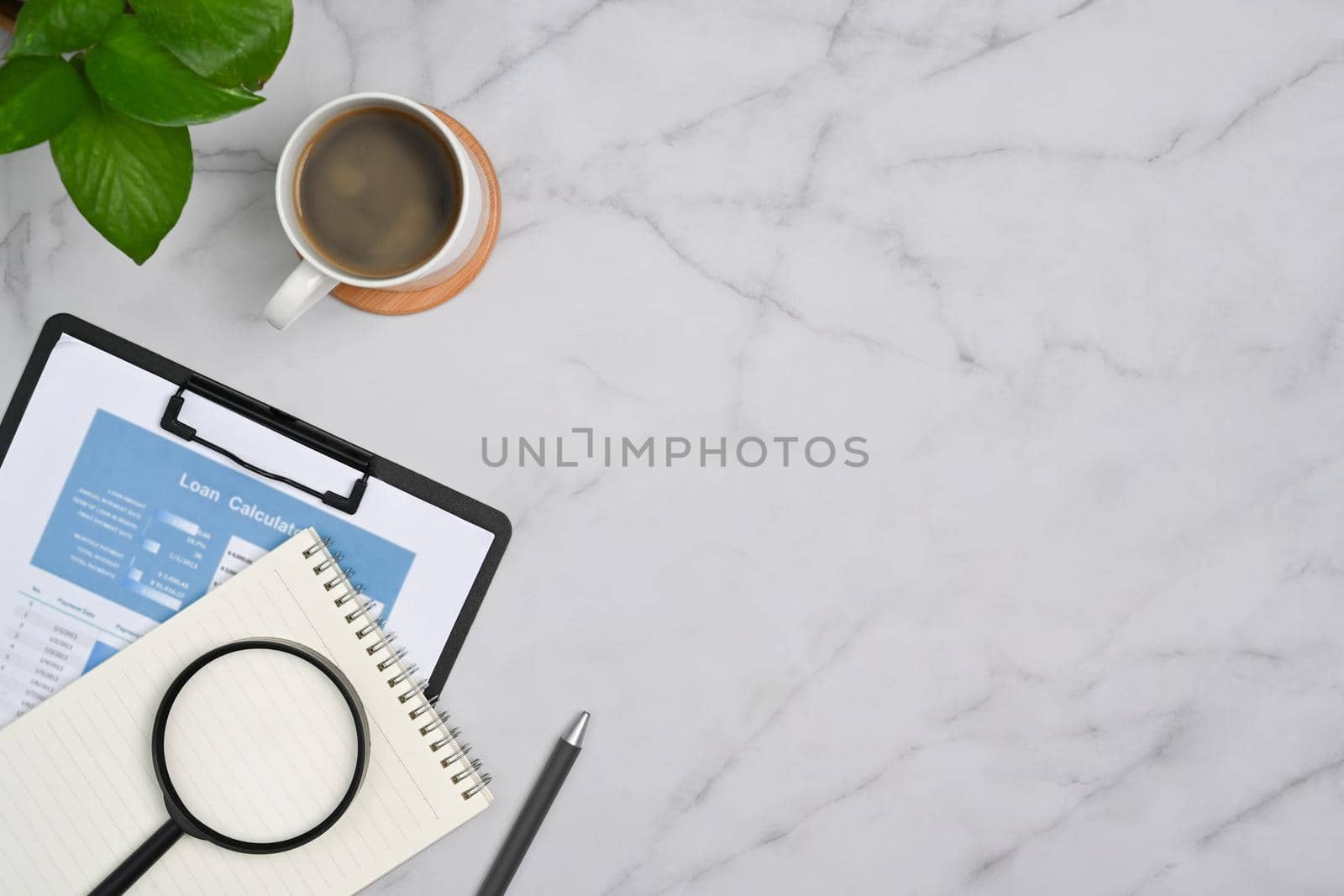 Top view financial document, magnifying glass, coffee cup and notepad on marble background with copy space by prathanchorruangsak