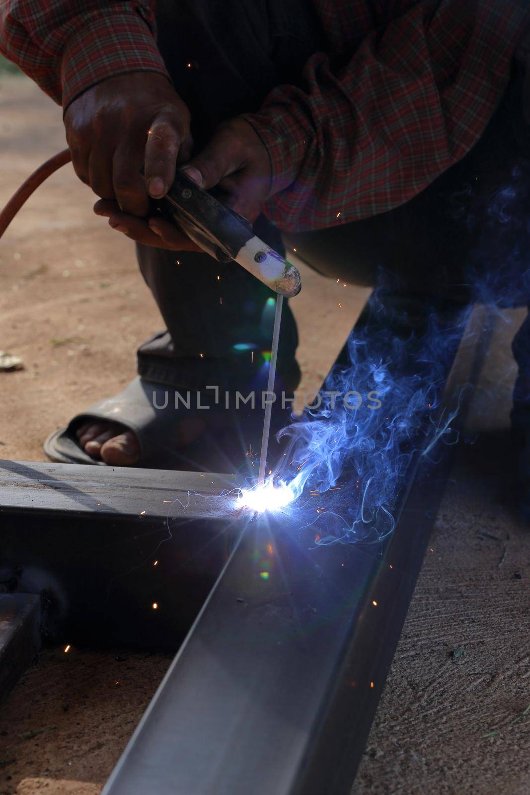 close up hand of worker welding metal