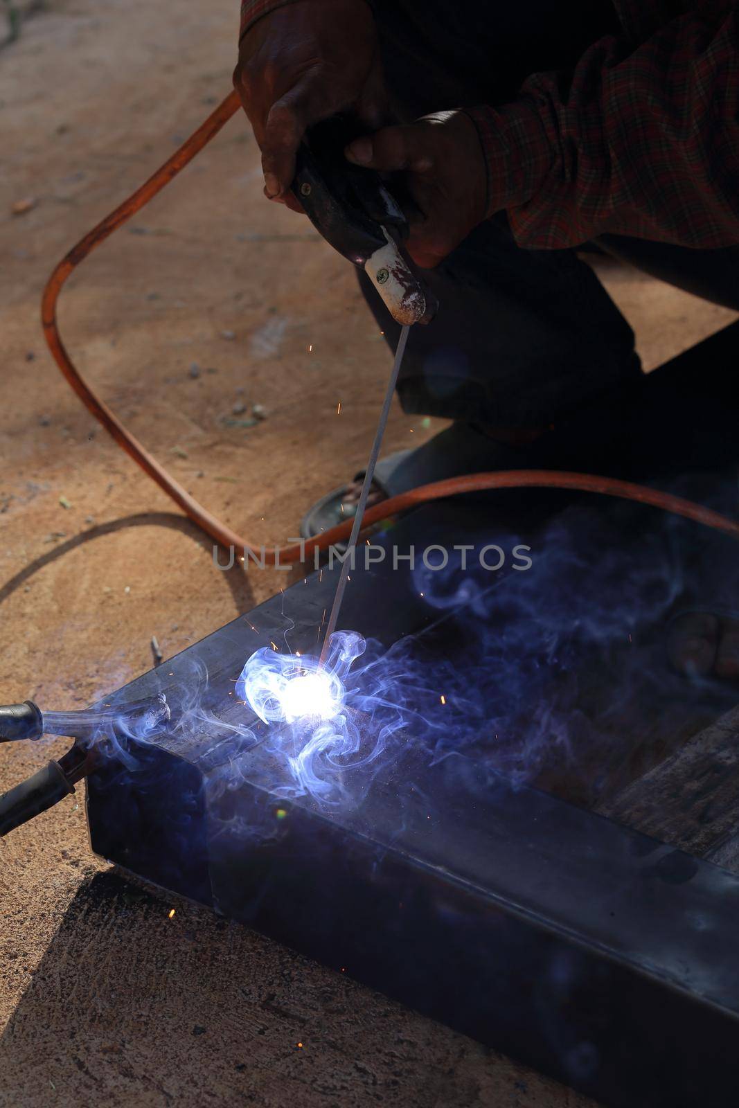 hand of worker welding metal by geargodz