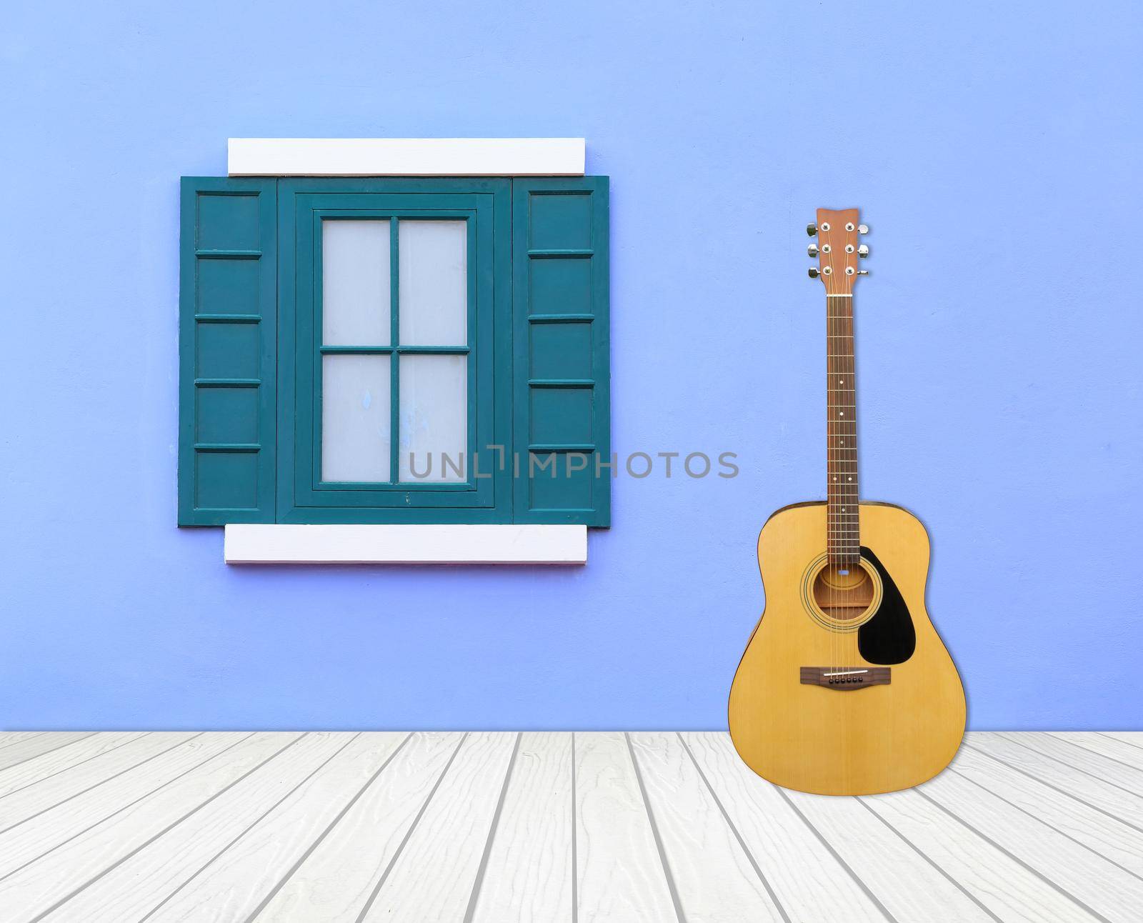 Guitar with window on cement wall and wood floor