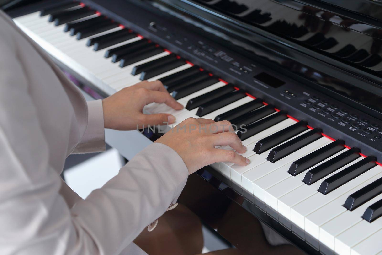 hands of a young woman playing piano