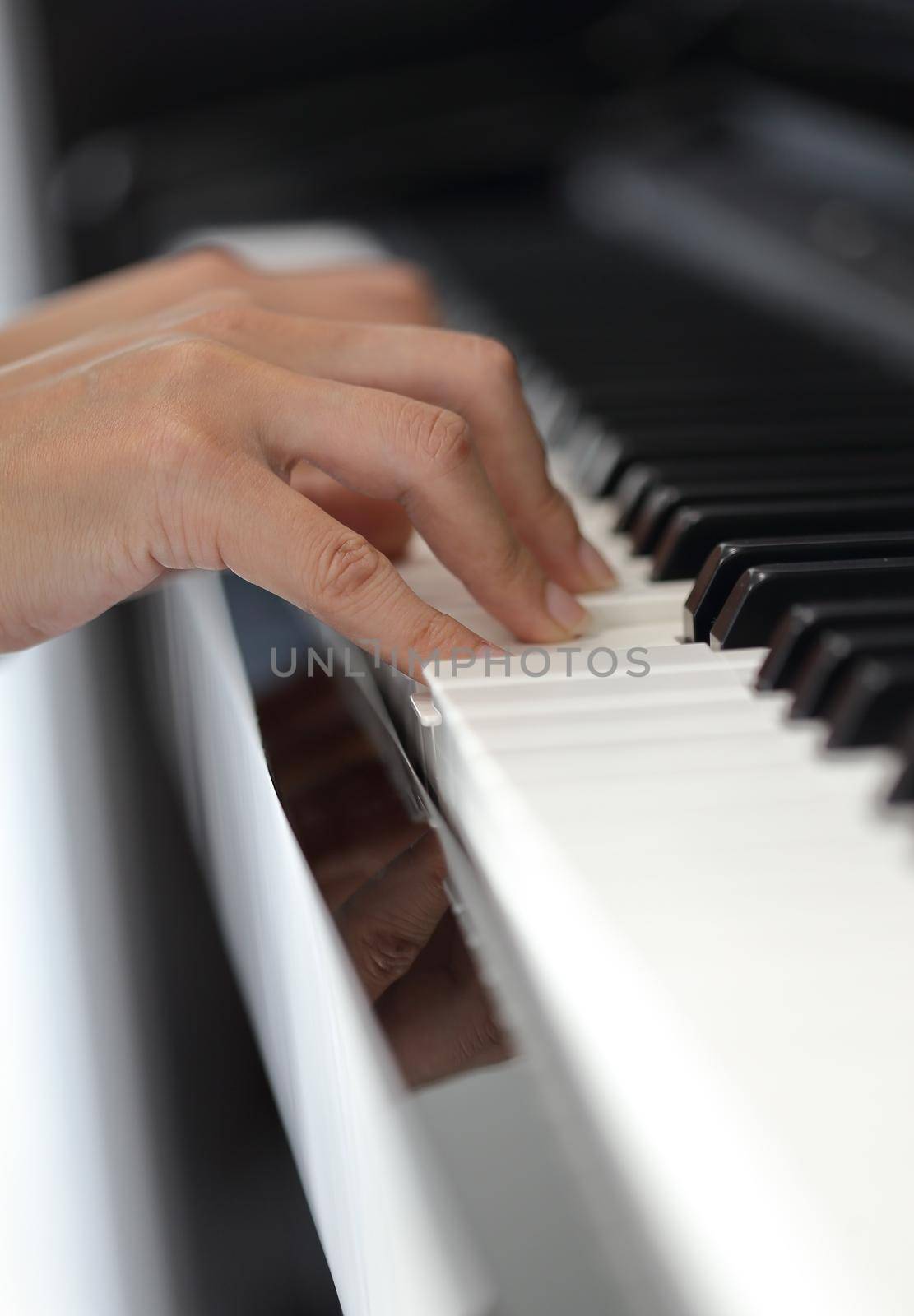 Close up of the hands of a young woman playing piano