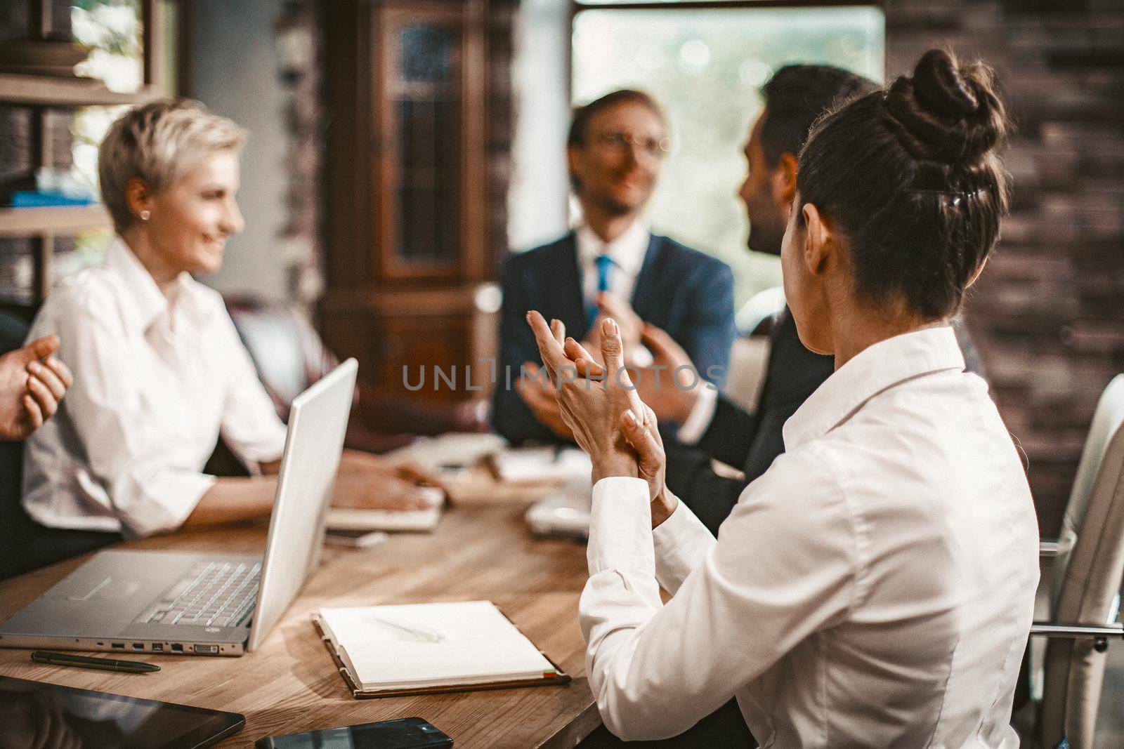 Teamwork Of Successful Business People, Selective Focus On Young Businesswoman Clapping With Her Hands, View From Back, Coworkers Team In Formalwear Working On Blurred Background, Toned Image