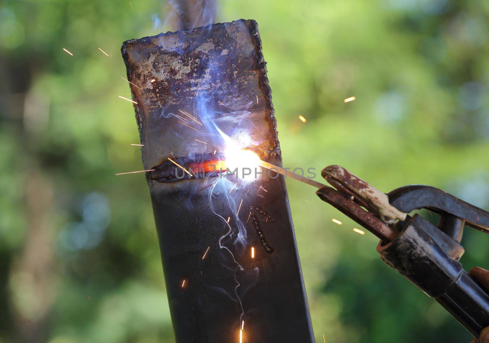 close up hand of worker welding metal